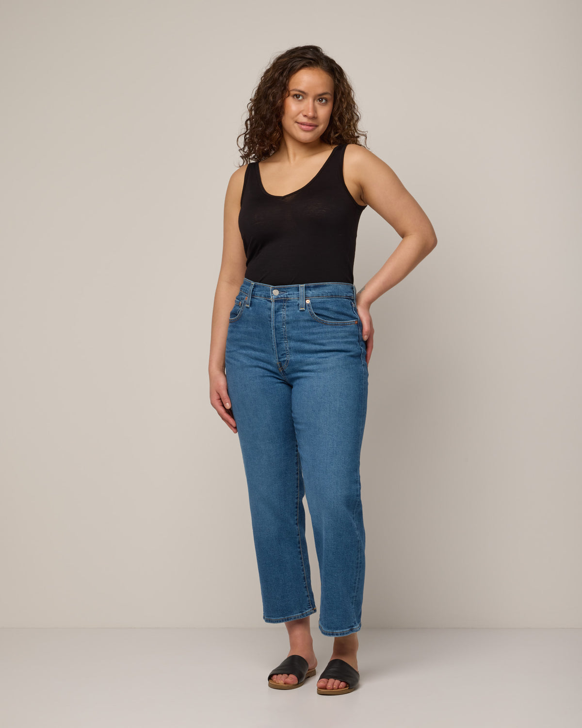 Model wearing Essential Layering Tank in Black. Essential Layering Tank is a merino wool sleeveless, reversible, slim fit top available in sizes XS-3X.
