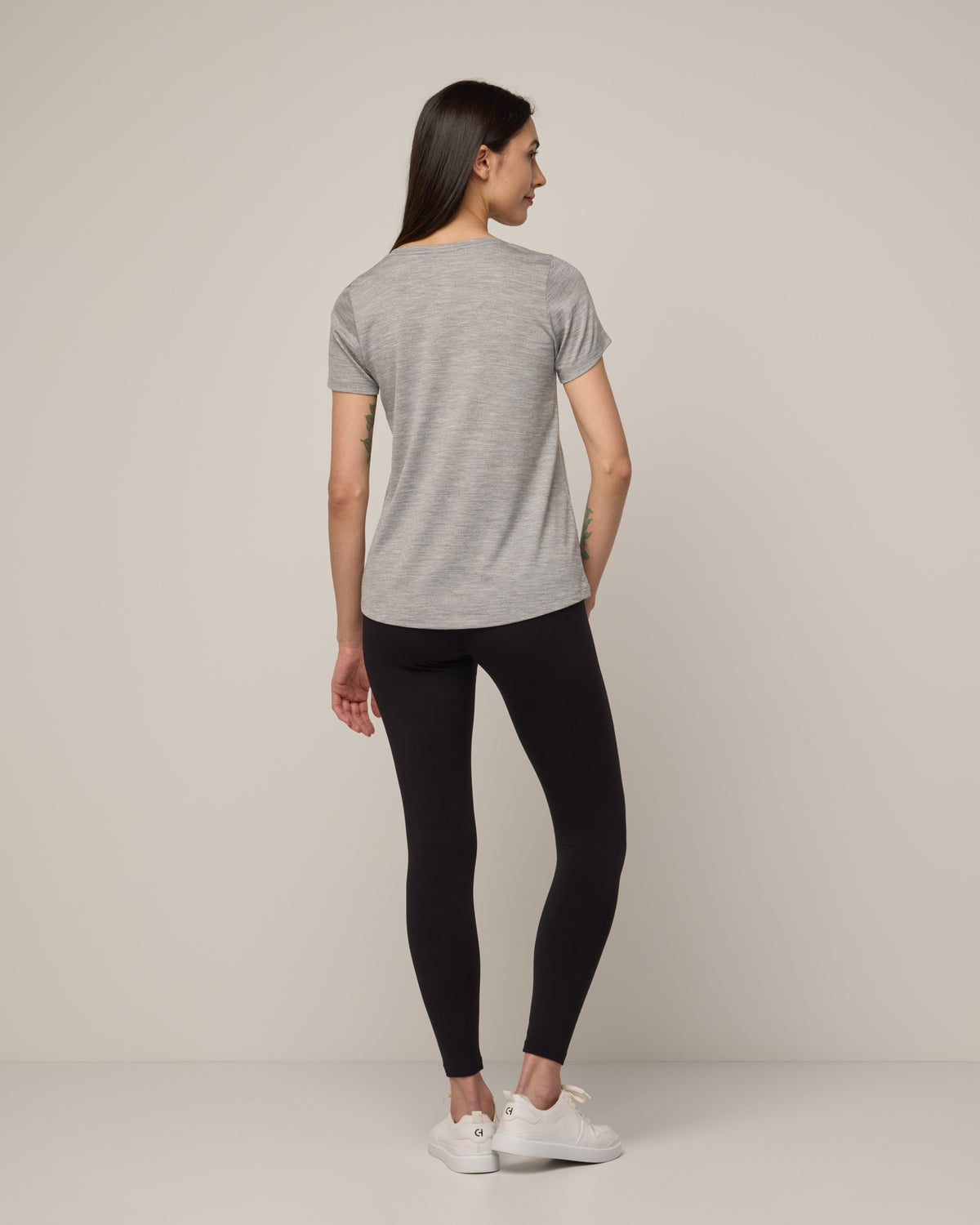 Model wearing Stella Signature Scoop Neck Tee in Gray Heather. Stella Signature Scoop Neck Tee is a merino wool short sleeve, scoop neck, relaxed fit tee available in sizes XS-3X.
