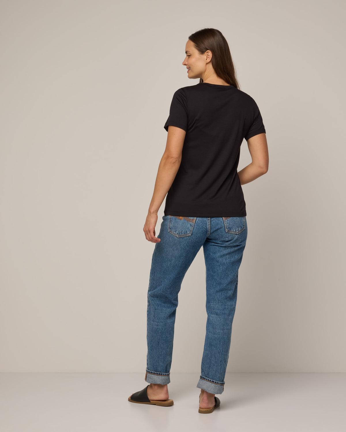 Model wearing Cara Signature Fitted Tee in Black. Cara Signature Fitted Tee is a merino wool short sleeve, crew neck, slim fit tee available in sizes XS-3X.