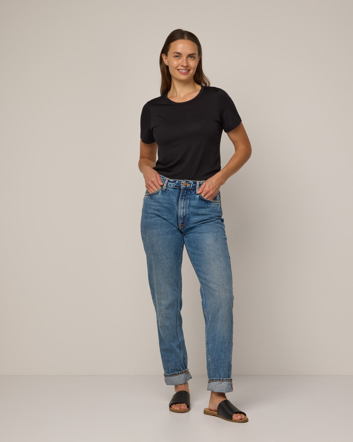 Model wearing Cara Signature Fitted Tee in Black. Cara Signature Fitted Tee is a merino wool short sleeve, crew neck, slim fit tee available in sizes XS-3X.