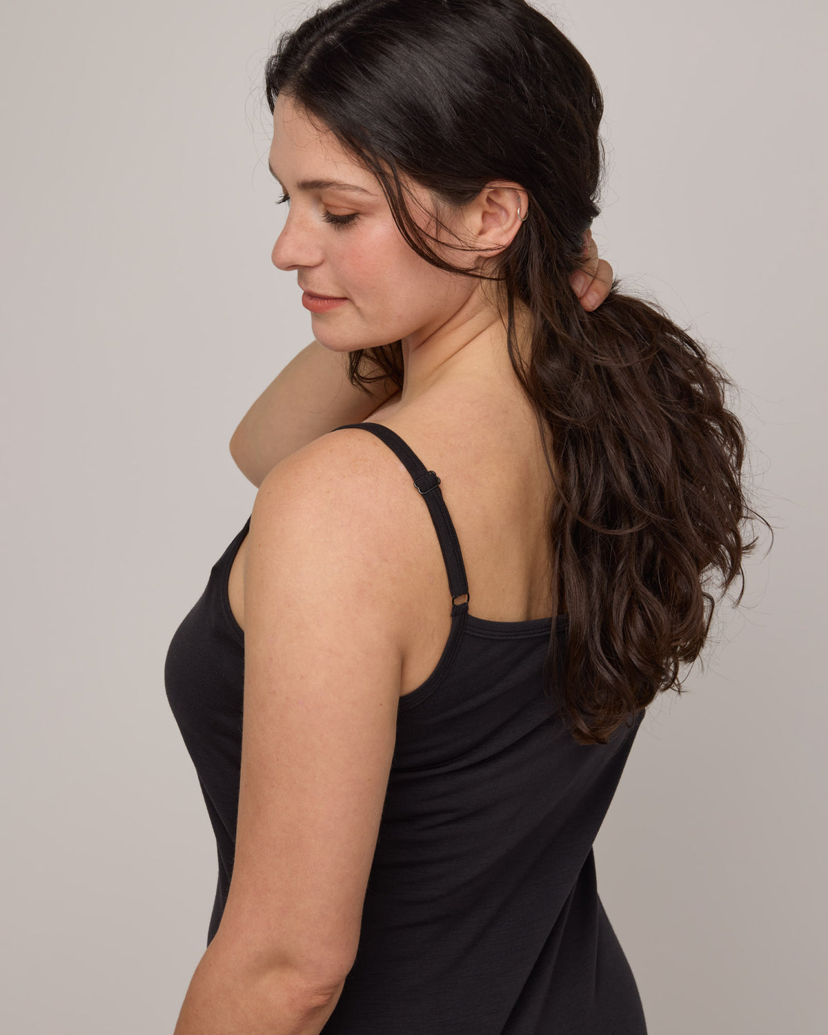 Model wearing Roam Cami Slip in Black. Roam Cami Slip is a merino wool sleeveless, scoop neck, knee length fitted underwear available in sizes XS-3X.
