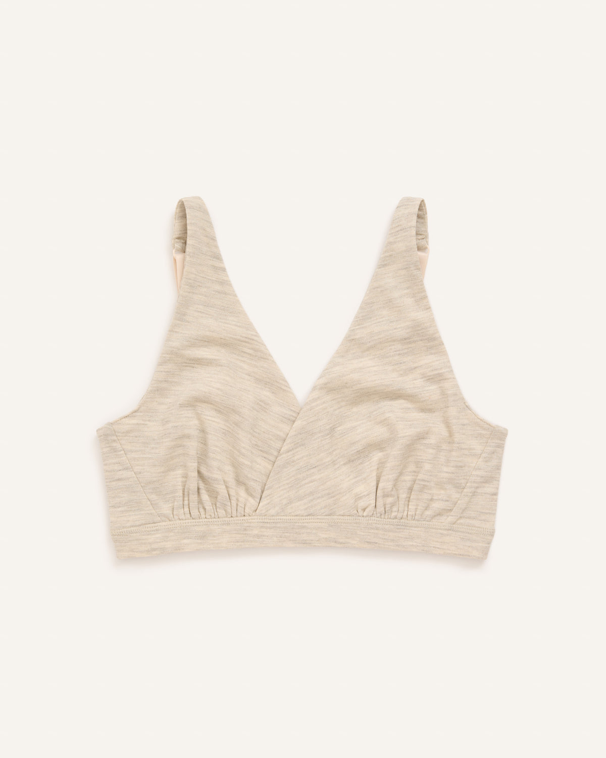Model wearing Roam Convertible Wrap Bra in Oatmeal Heather, a soft heathered cream color. Roam Convertible Wrap Bra is a merino wool underwear available in sizes XS-XXL.