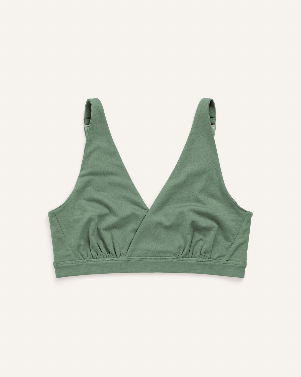 Model wearing Roam Convertible Wrap Bra in Spruce Green, a medium green color with blue undertones. Roam Convertible Wrap Bra is a merino wool underwear available in sizes XS-XXL.