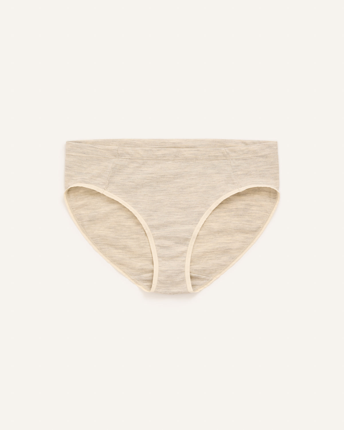 Model wearing Roam Bikini in Oatmeal Heather, a soft heathered cream color. Roam Bikini is a merino wool underwear available in sizes XS-3X.