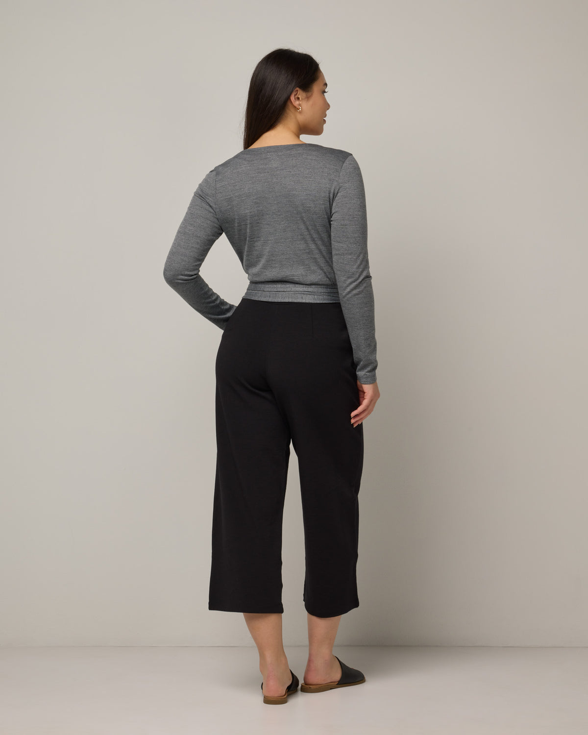 Model wearing Natalia Wrap Top in Charcoal Heather. Natalia Wrap Top is a merino wool long sleeve, v-neck, slim fit top available in sizes XS-3X.