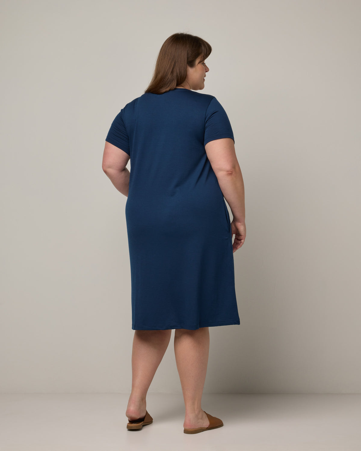 Model wearing Maggie Swing Dress in Marine Blue, a deep royal blue color. Maggie Swing Dress is a merino wool short sleeve, scoop neck, knee length swing dress with pockets available in sizes XS-3X Regular, XS-3X Long.