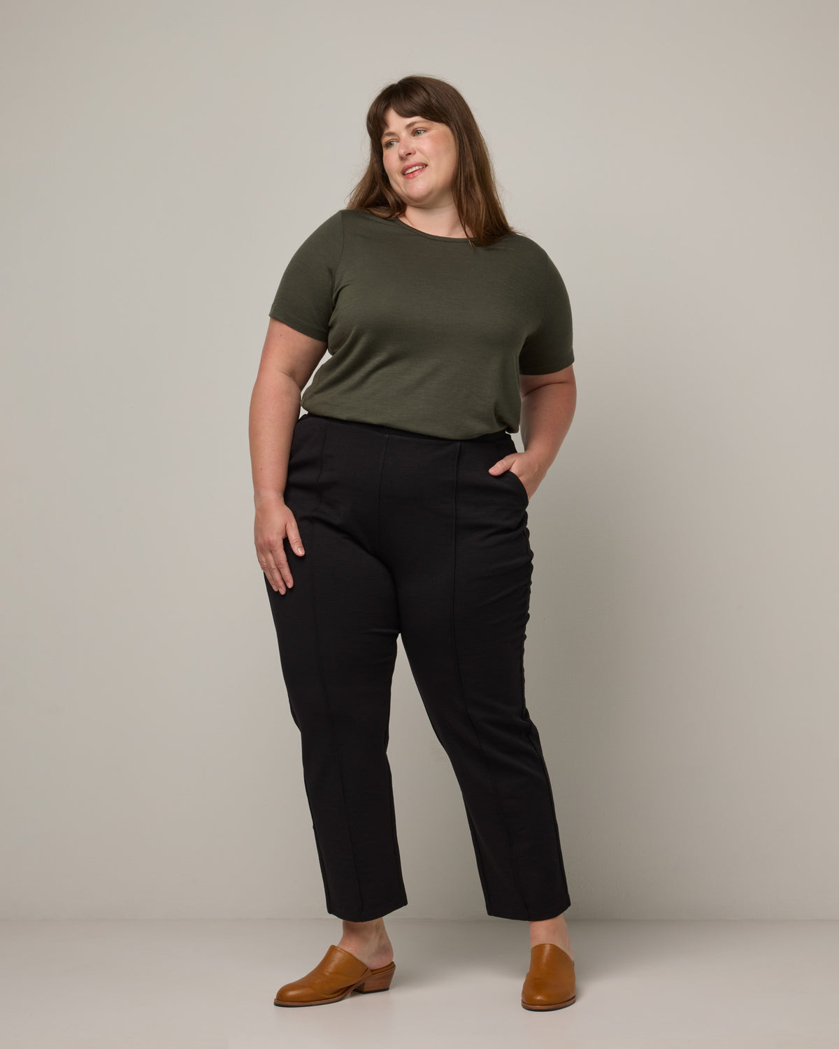 Model wearing Rosso Straight Ponte Pant in Black. Rosso Straight Ponte Pant is a merino wool pant with pockets available in sizes XS-3X Regular, S-XXL Long.