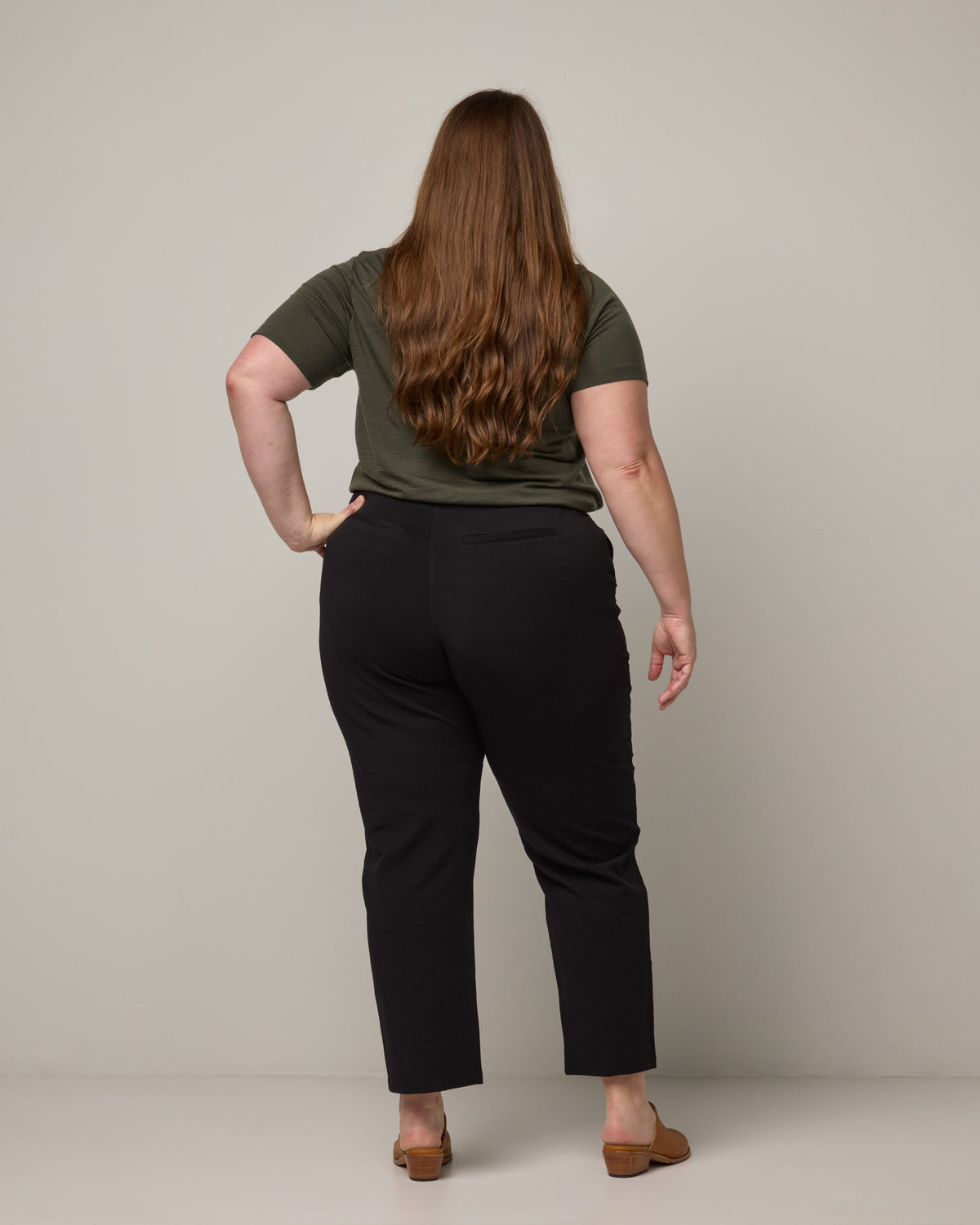 Model wearing Rosso Straight Ponte Pant in Black. Rosso Straight Ponte Pant is a merino wool pant with pockets available in sizes XS-3X Regular, S-XXL Long.