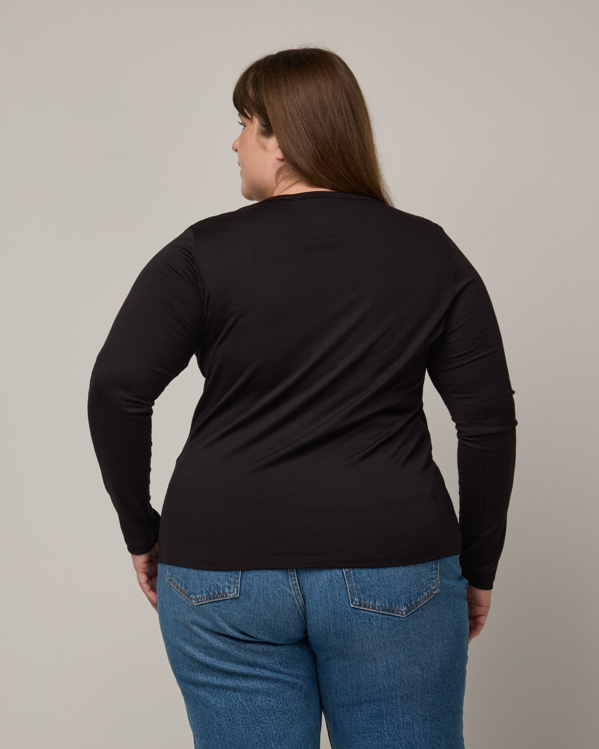Model wearing Sloan 100% Wool Fitted Tee in Black. Sloan 100% Wool Fitted Tee is a merino wool long sleeve, crew neck, slim fit tee available in sizes XS-3X.