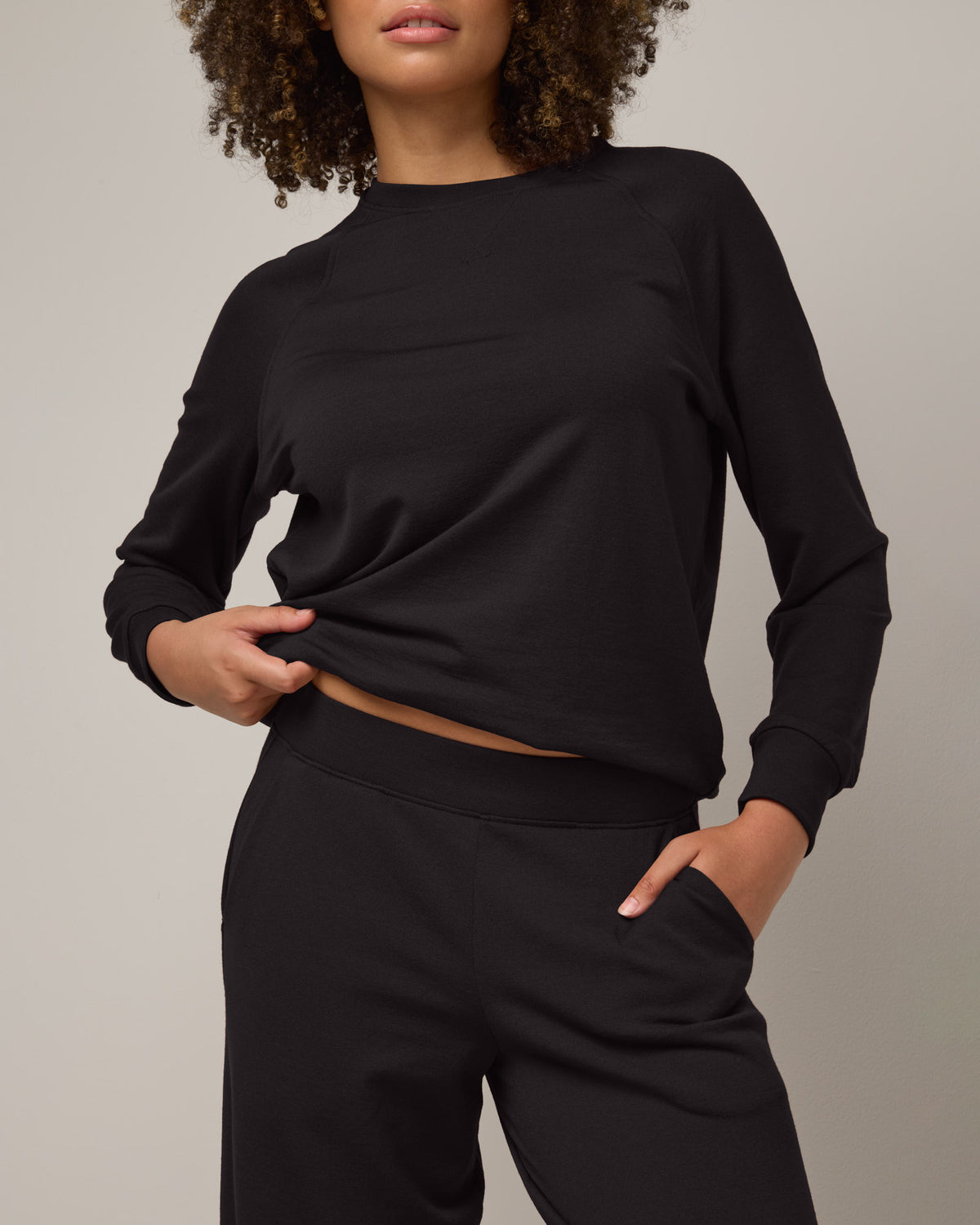 Model wearing Aspen Wide Leg Sweatpants in Black. Aspen Wide Leg Sweatpants is a merino wool sweatpant with pockets available in sizes XS-3X.