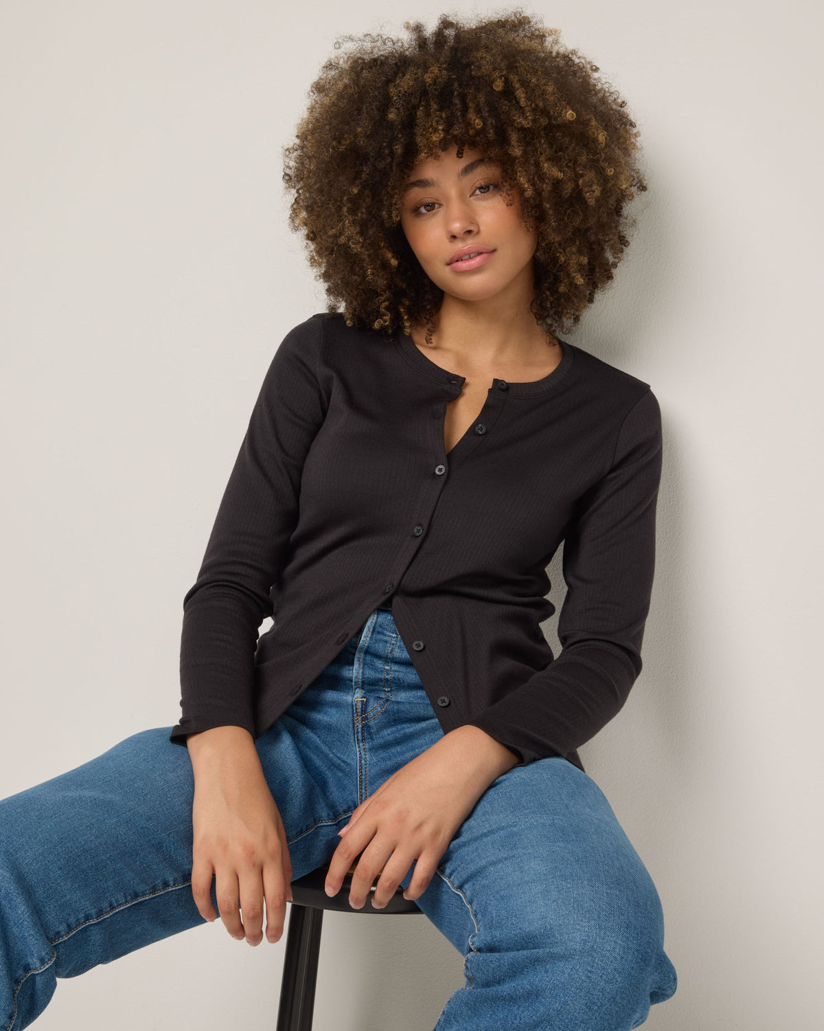 Model wearing Celeste Ribbed Cardigan in Black. Celeste Ribbed Cardigan is a merino wool long sleeve, cardigan available in sizes XS-3X.