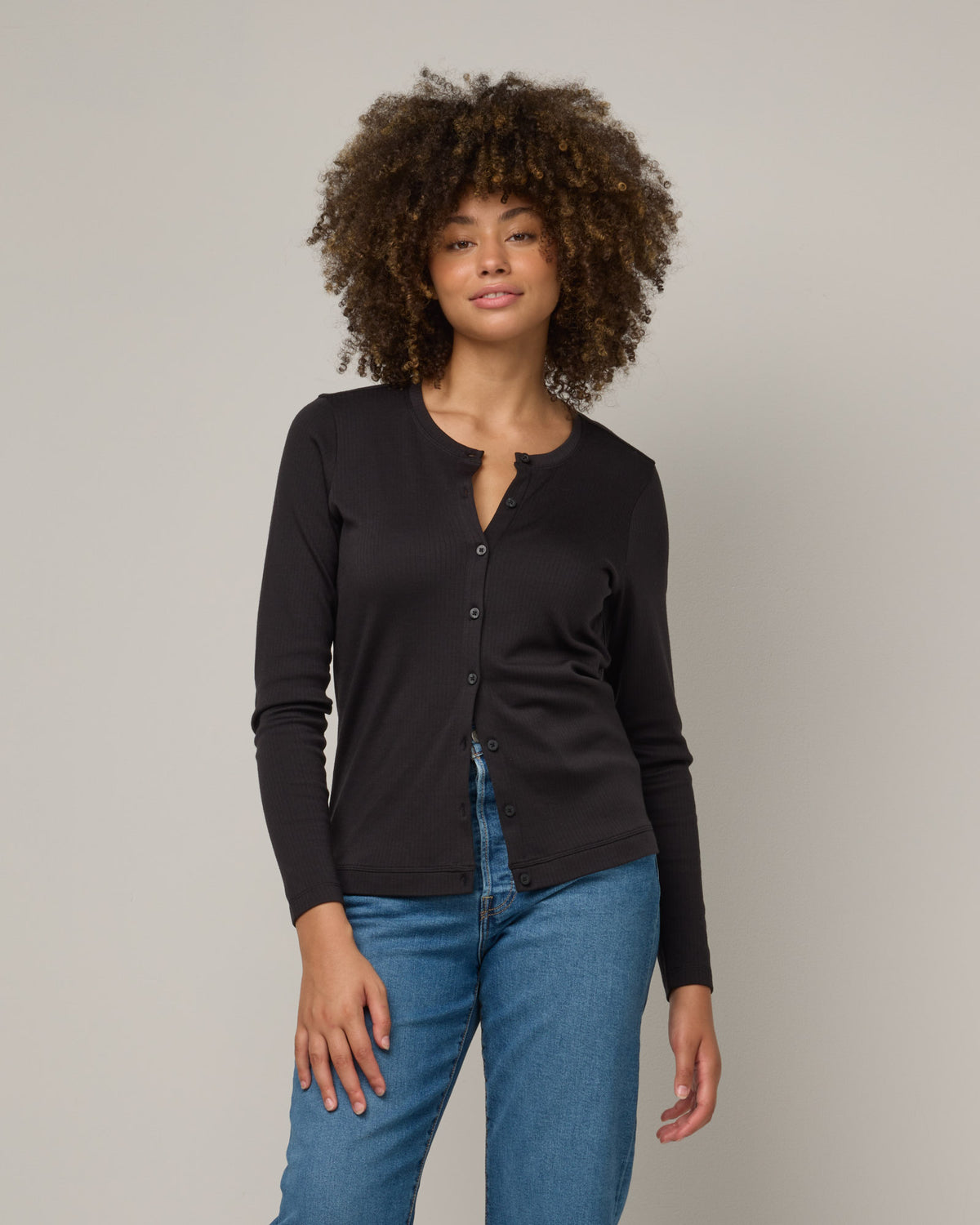 Model wearing Celeste Ribbed Cardigan in Black. Celeste Ribbed Cardigan is a merino wool long sleeve, cardigan available in sizes XS-3X.