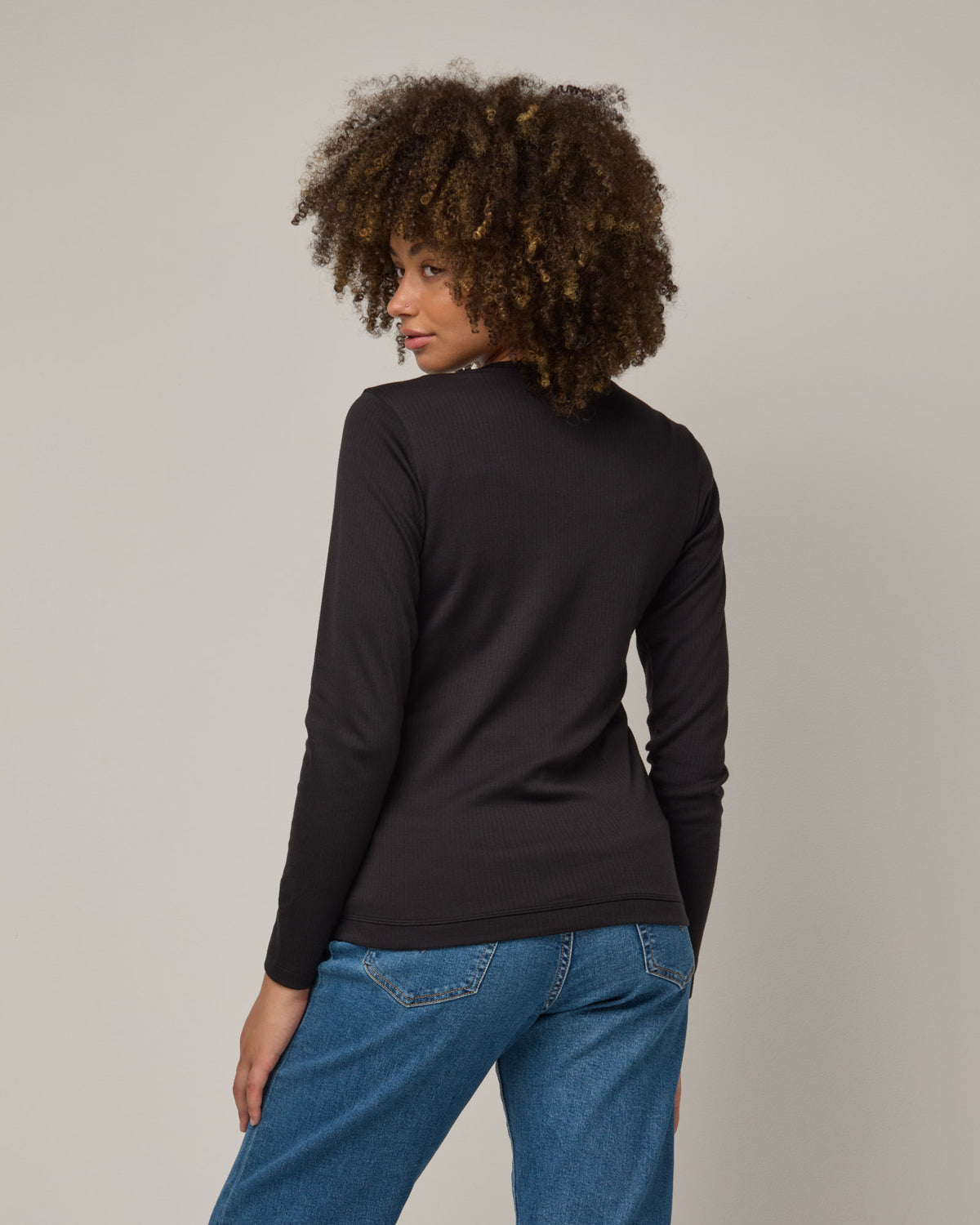 Model wearing Celeste Ribbed Cardigan in Black. Celeste Ribbed Cardigan is a merino wool long sleeve, cardigan available in sizes XS-3X.