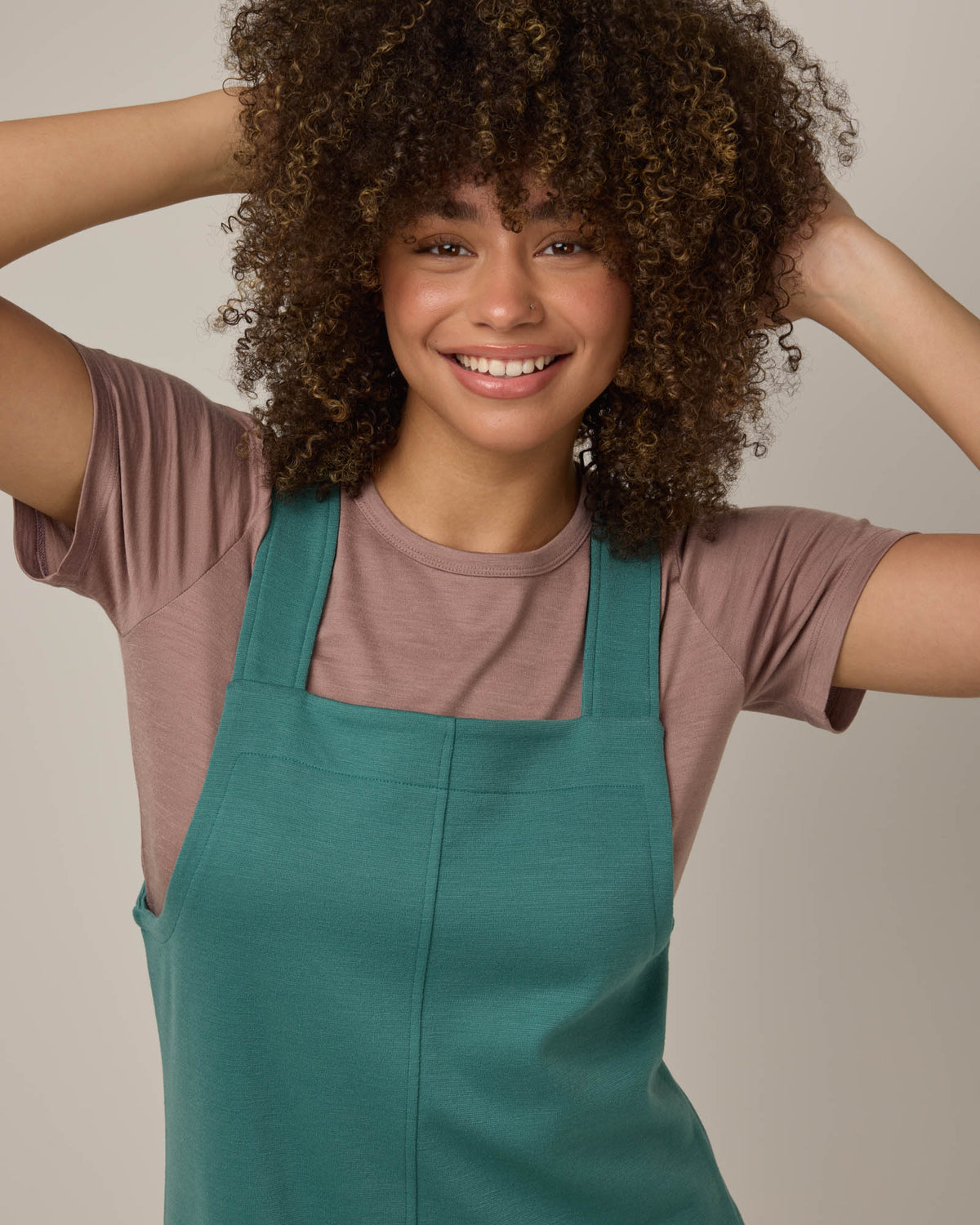 Model wearing Goldie Pinafore Dress in Silver Jade, a soft green-blue color. Goldie Pinafore Dress is a merino wool sleeveless, square neck, knee length shift dress with pockets available in sizes XS-3X.