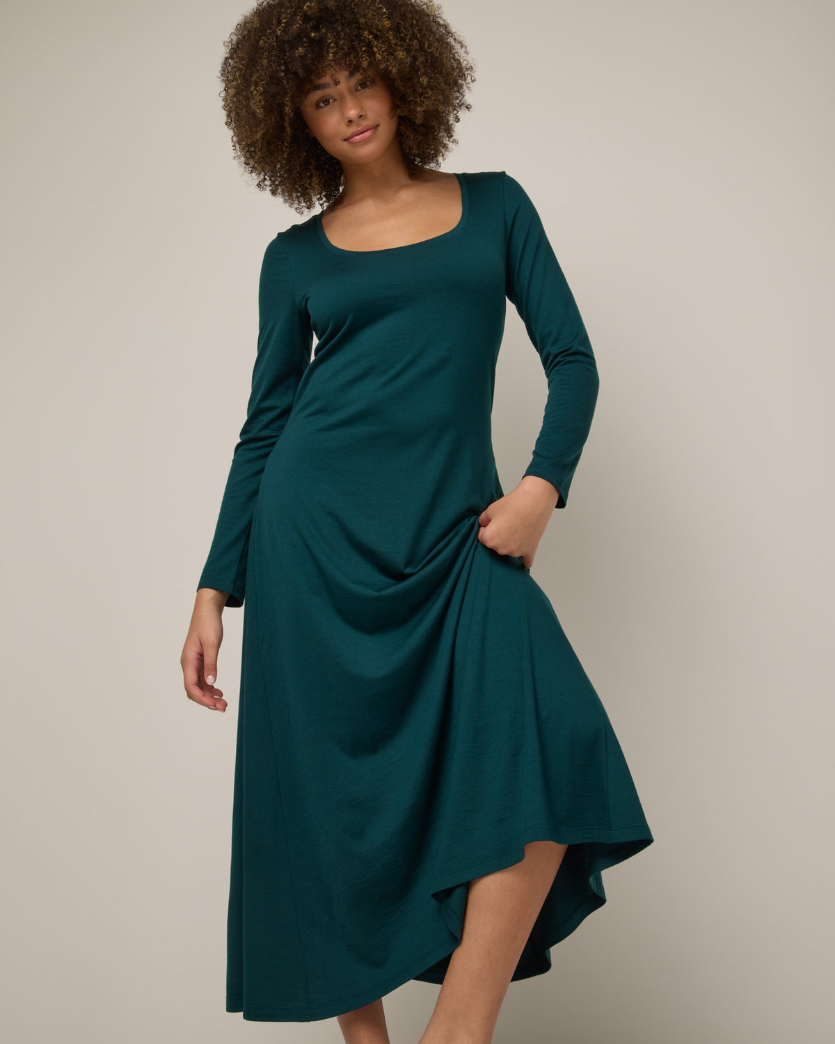 Model wearing Valerie Maxi Dress in Pine, a saturated forest green color. Valerie Maxi Dress is a merino wool long sleeve, scoop neck, maxi swing dress available in sizes XS-XXL.