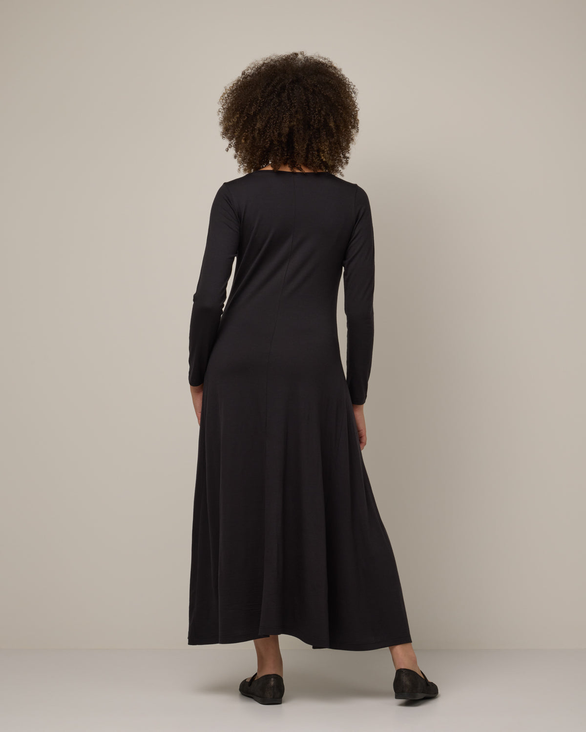 Model wearing Valerie Maxi Dress in Black. Valerie Maxi Dress is a merino wool long sleeve, scoop neck, maxi swing dress available in sizes XS-XXL.