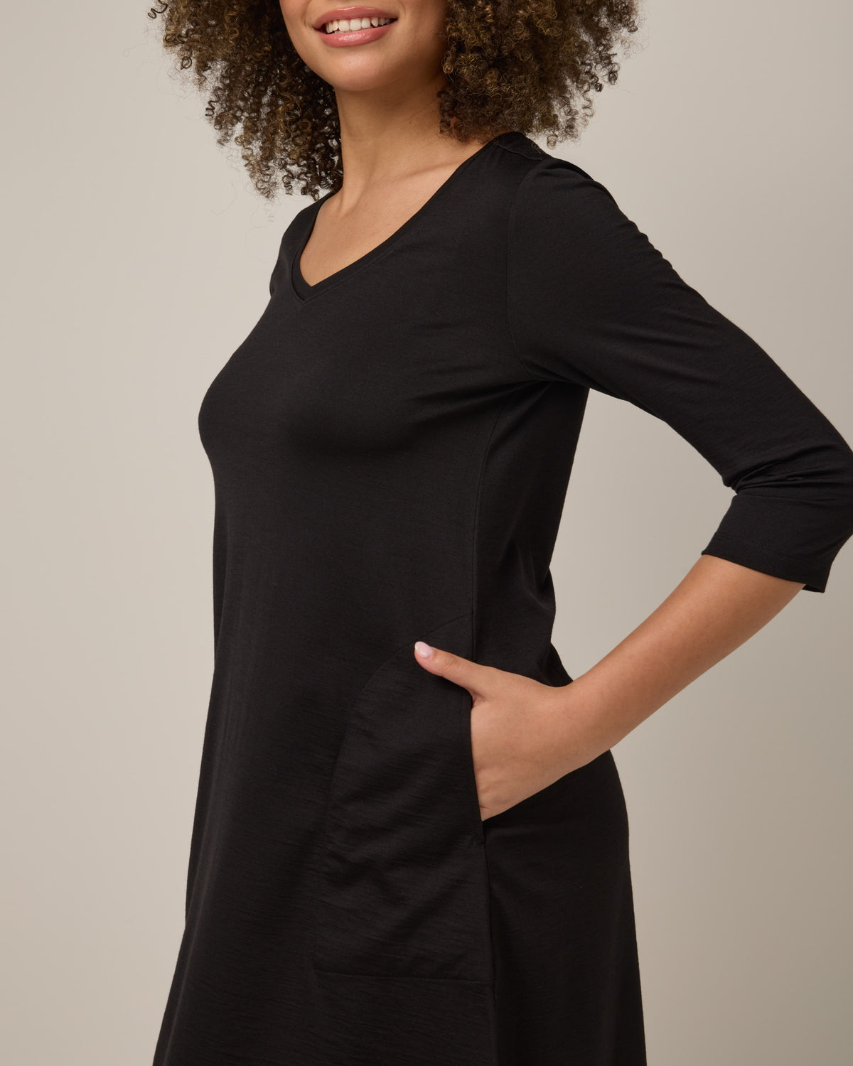 Model wearing Willow Swing Dress in Black. Willow Swing Dress is a merino wool long sleeve, v-neck, knee length swing dress with pockets available in sizes XS-3X Regular, XS-3X Long.