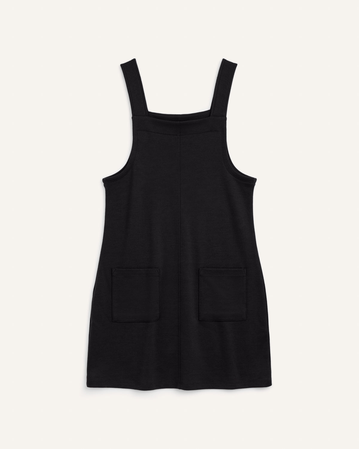 Laydown of Goldie Pinafore Dress in Black. Goldie Pinafore Dress is a merino wool sleeveless, square neck, knee length shift dress with pockets available in sizes XS-3X.