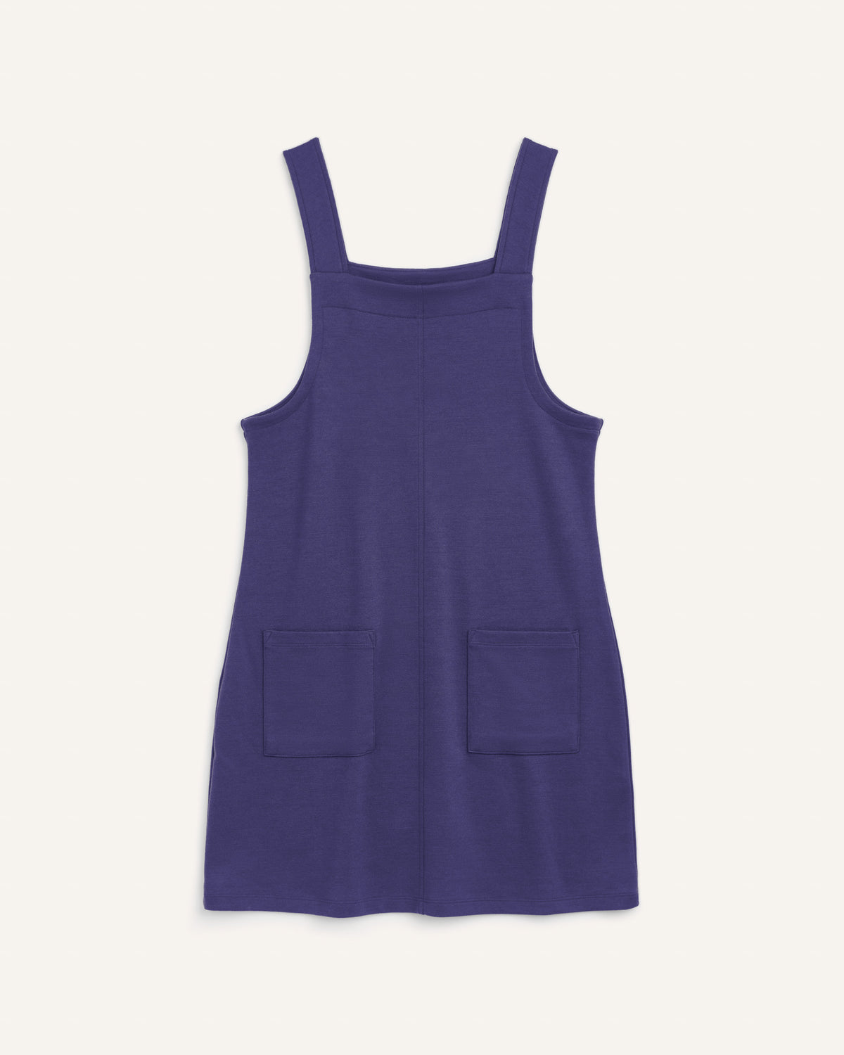 Laydown of Goldie Pinafore Dress in Iris Blue, a vibrant purple-blue color. Goldie Pinafore Dress is a merino wool sleeveless, square neck, knee length shift dress with pockets available in sizes XS-3X.
