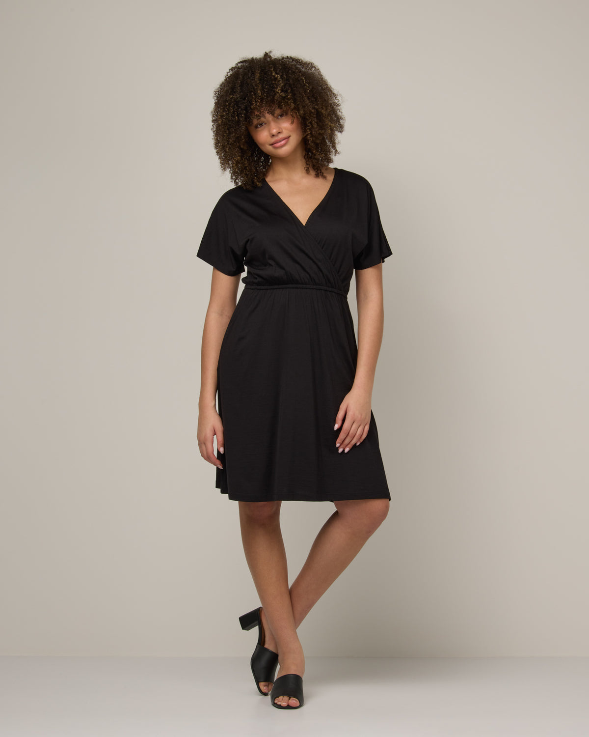 Model wearing Brooklyn Reversible Dress in Black. Brooklyn Reversible Dress is a merino wool short sleeve, reversible, knee length fit & flare dress with pockets available in sizes XS-3X Regular, XS-XL Long.