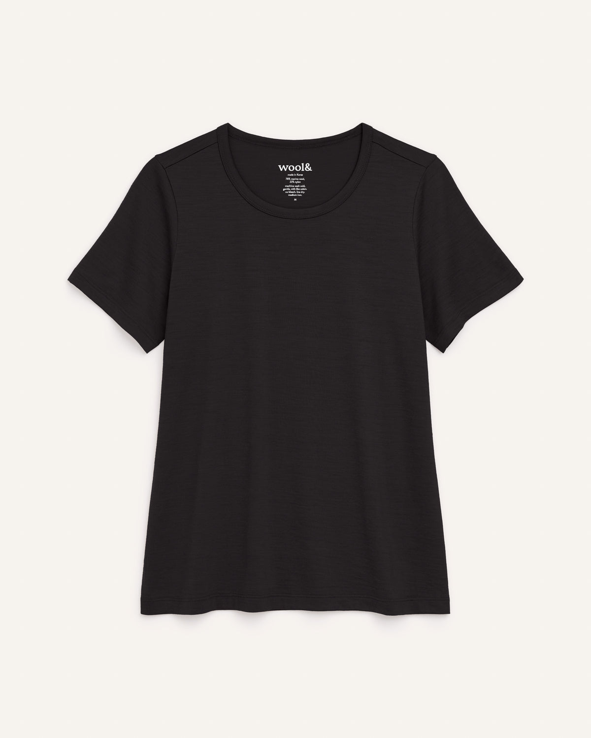 Laydown of Cara Signature Fitted Tee in Black. Cara Signature Fitted Tee is a merino wool short sleeve, crew neck, slim fit tee available in sizes XS-3X.
