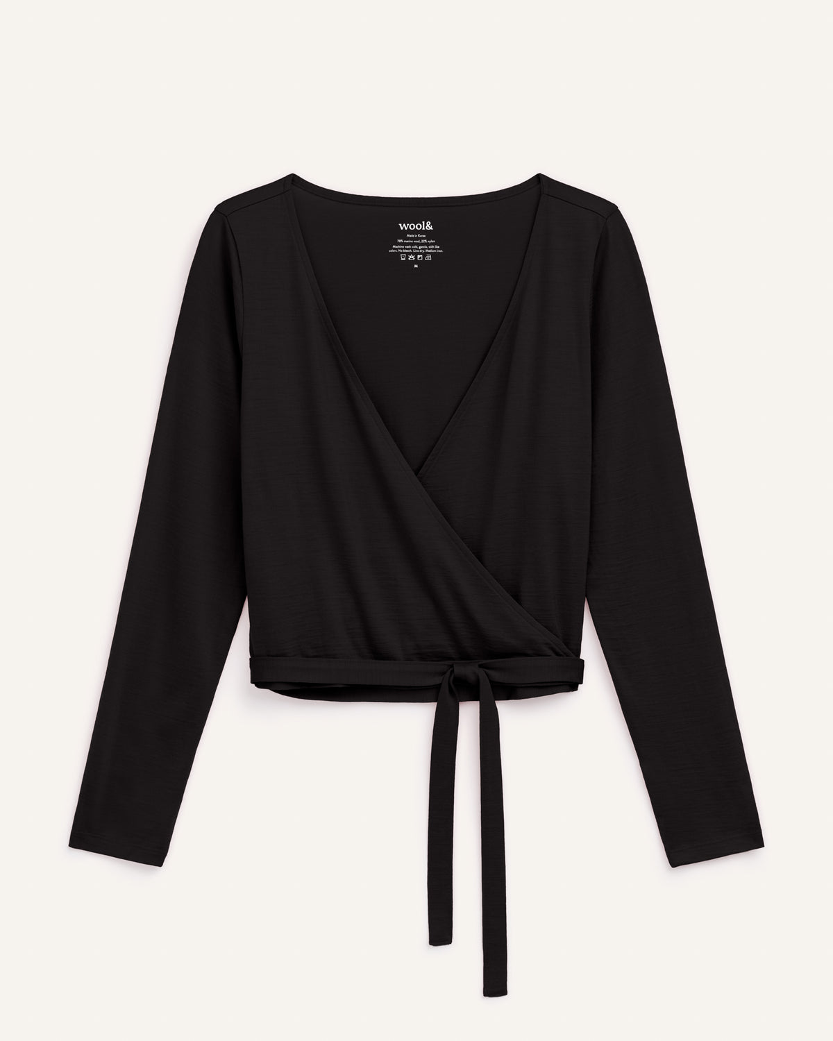 Laydown of Natalia Wrap Top in Black. Natalia Wrap Top is a merino wool long sleeve, v-neck, slim fit top available in sizes XS-3X.