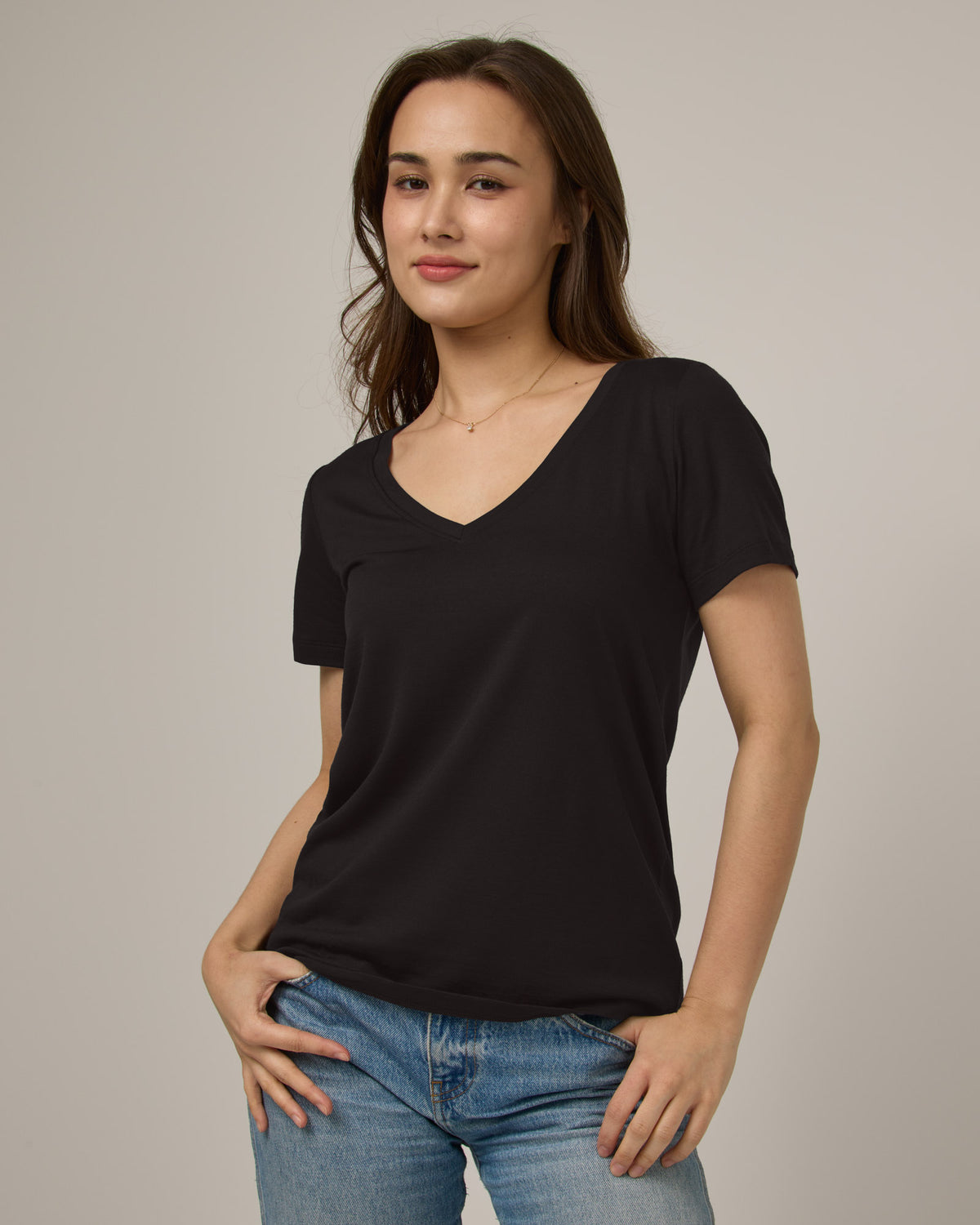 Model wearing Morgan V-Neck Tee in Black. Morgan V-Neck Tee is a merino wool short sleeve, v-neck, regular fit tee available in sizes XS-3X.
