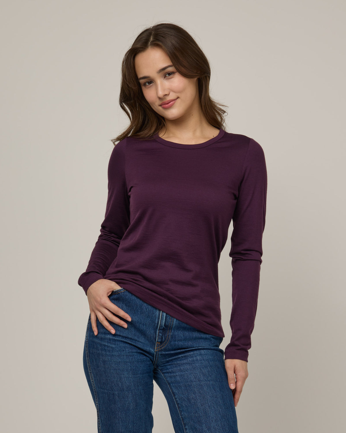 Model wearing Sloan Signature Fitted Tee in Marionberry, a dark berry purple color. Sloan Signature Fitted Tee is a merino wool long sleeve, crew neck, slim fit tee available in sizes XS-3X.