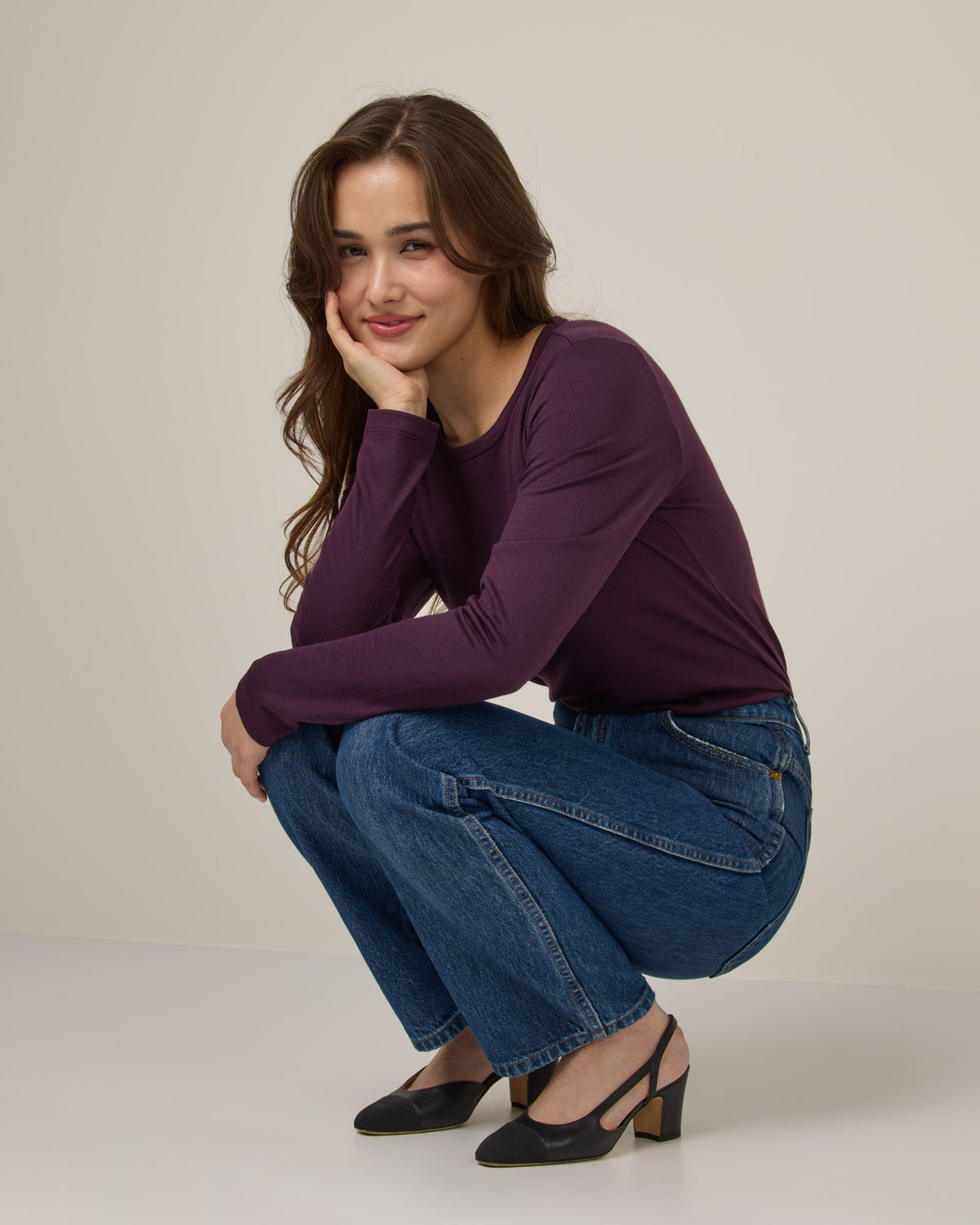 Model wearing Sloan Signature Fitted Tee in Marionberry, a dark berry purple color. Sloan Signature Fitted Tee is a merino wool long sleeve, crew neck, slim fit tee available in sizes XS-3X.