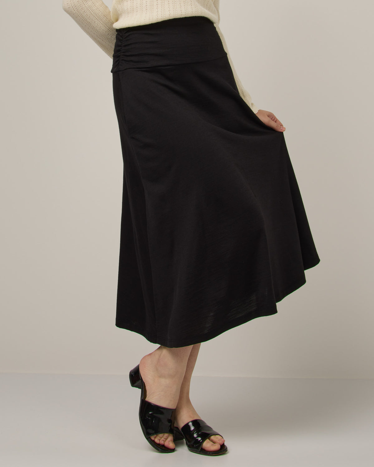 Model wearing Helena Midi Skirt in Black. Helena Midi Skirt is a merino wool midi skirt with pockets available in sizes XS-3X.