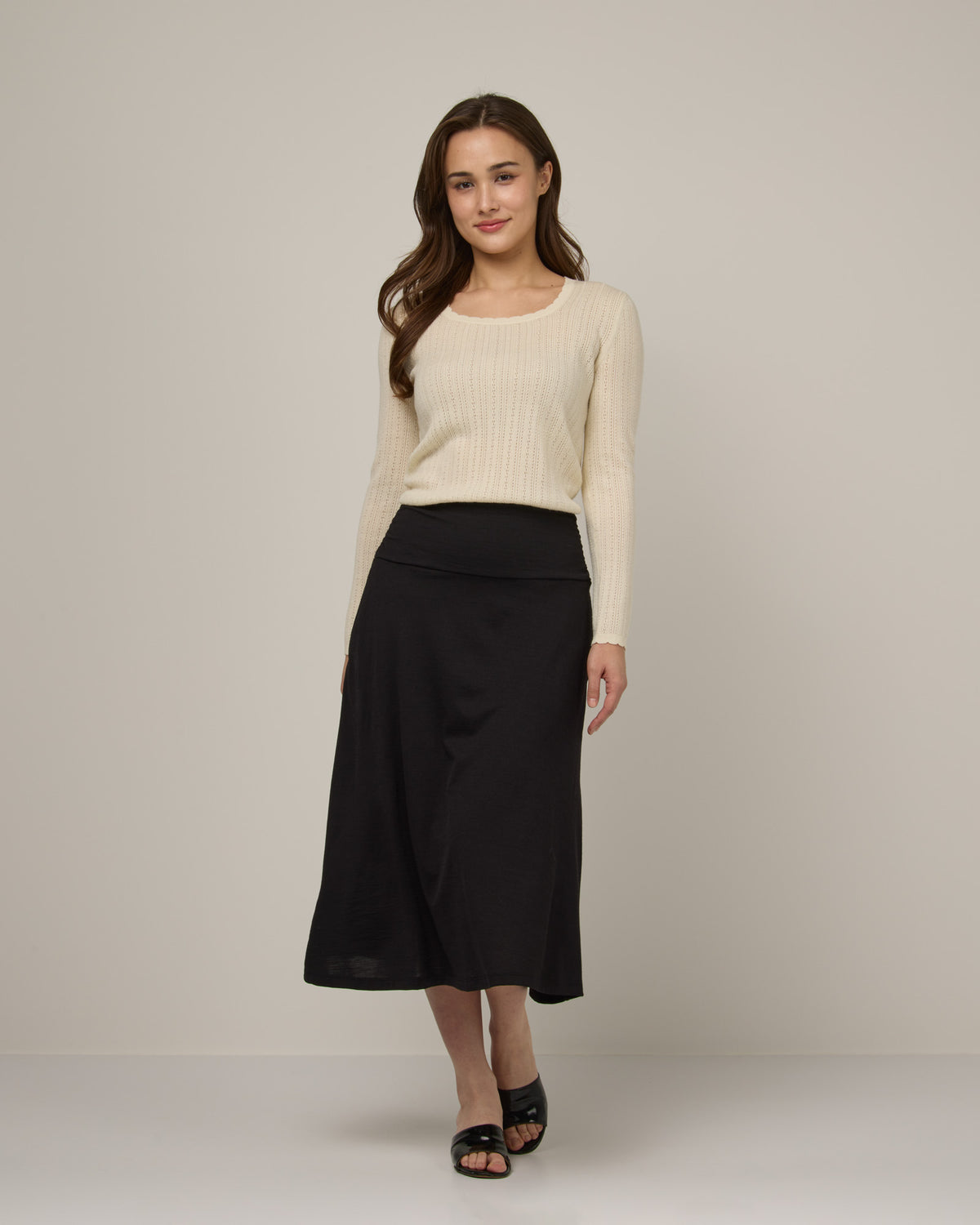 Model wearing Helena Midi Skirt in Black. Helena Midi Skirt is a merino wool midi skirt with pockets available in sizes XS-3X.