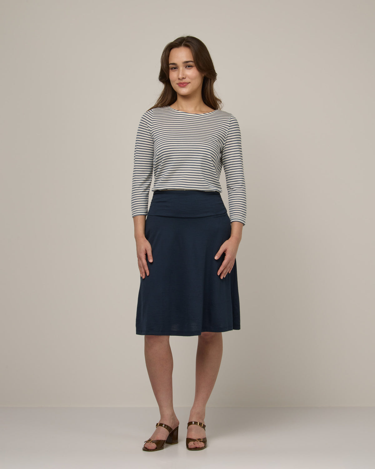 Model wearing Helena Skirt in Washed Navy. Helena Skirt is a merino wool knee length skirt with pockets available in sizes XS-3X.