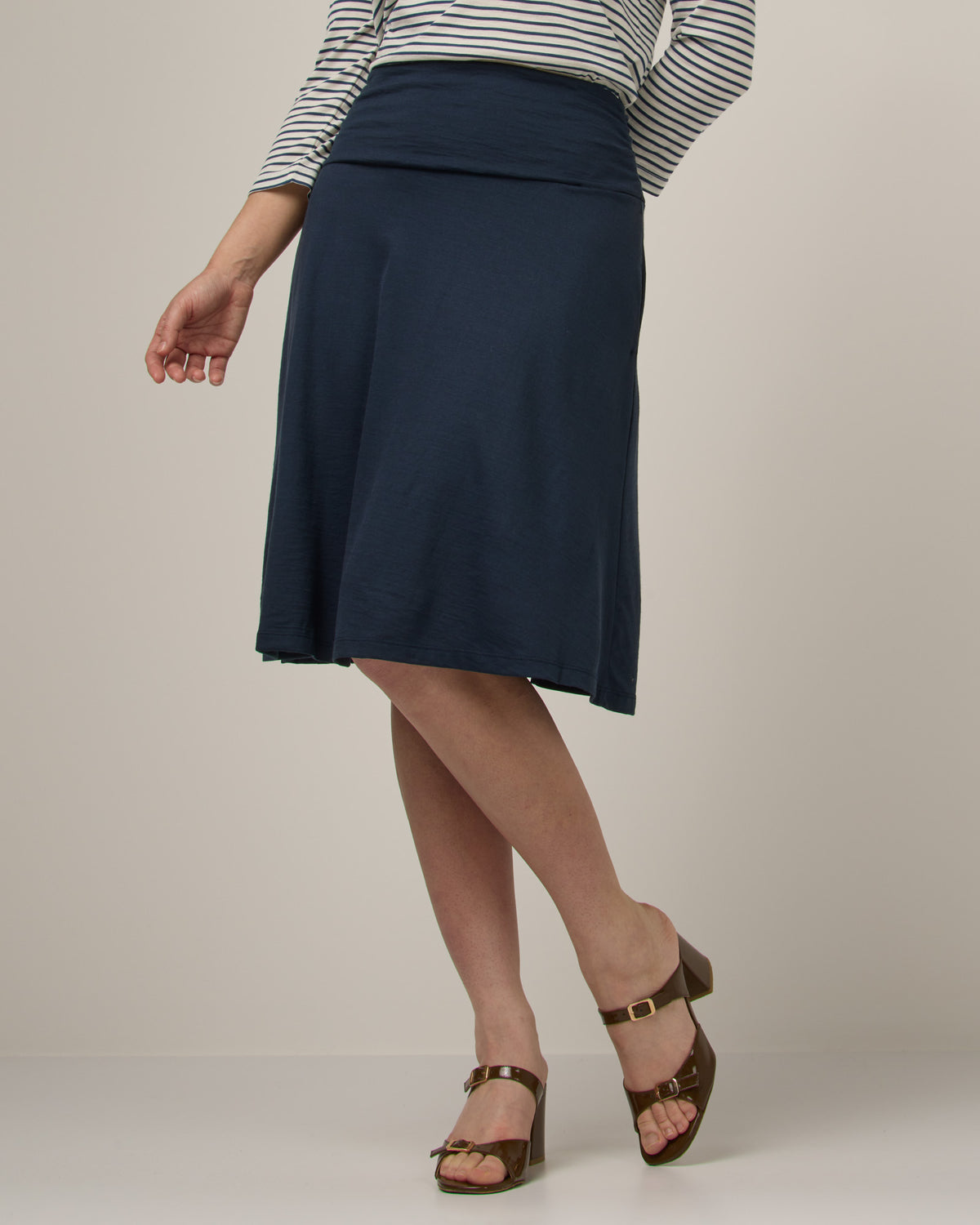 Model wearing Helena Skirt in Washed Navy. Helena Skirt is a merino wool knee length skirt with pockets available in sizes XS-3X.