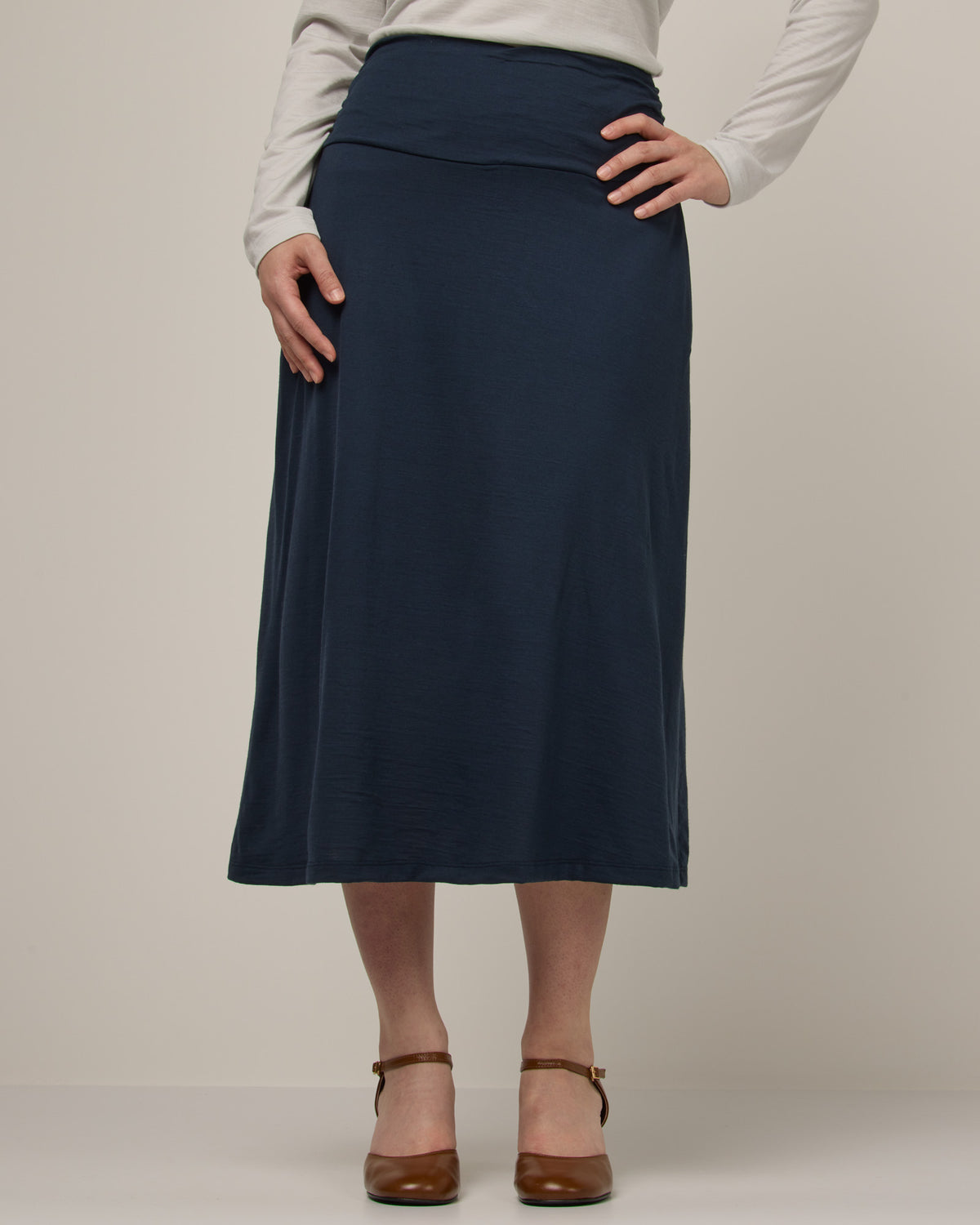 Model wearing Helena Midi Skirt in Washed Navy. Helena Midi Skirt is a merino wool midi skirt with pockets available in sizes XS-3X.