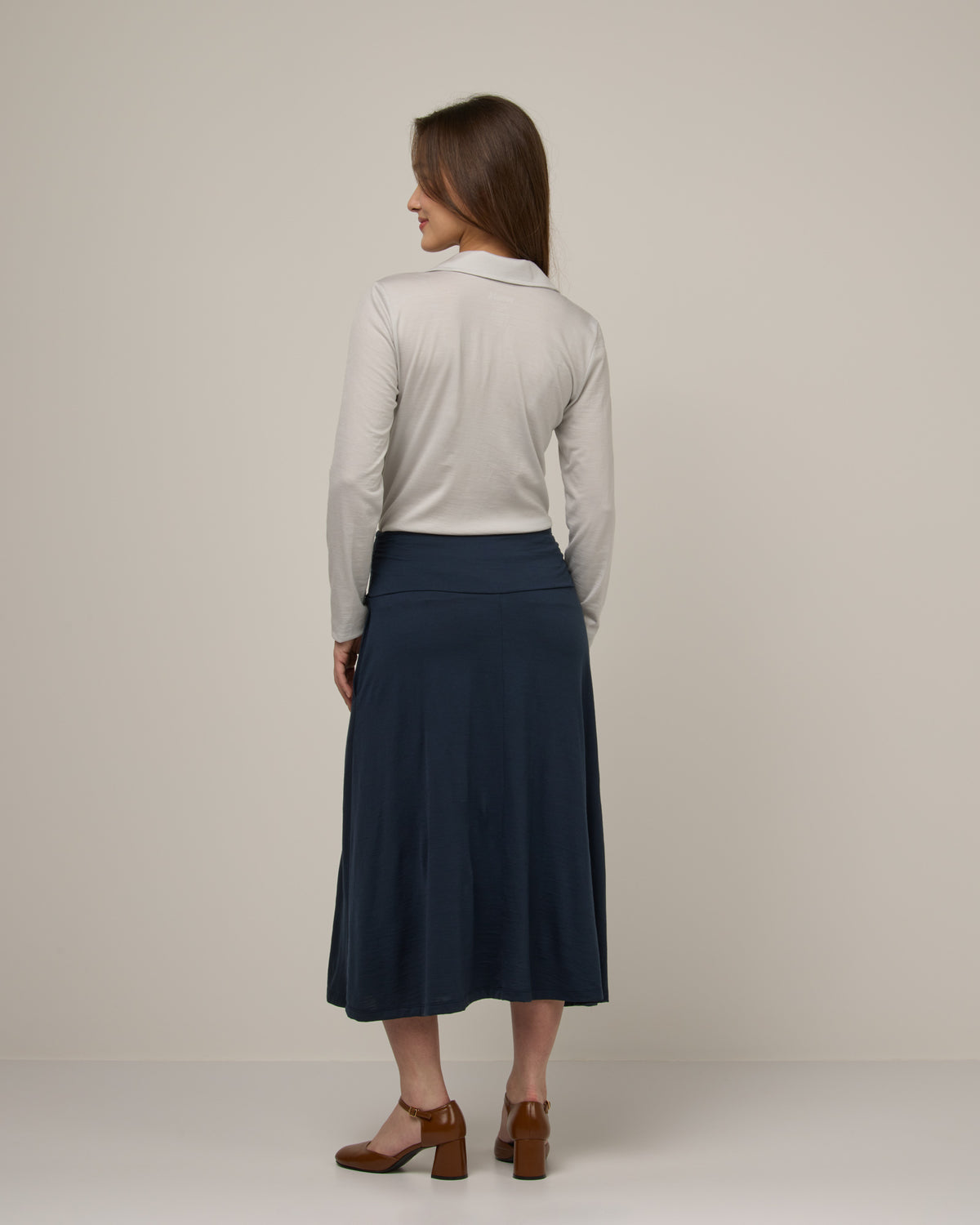 Model wearing Helena Midi Skirt in Washed Navy. Helena Midi Skirt is a merino wool midi skirt with pockets available in sizes XS-3X.