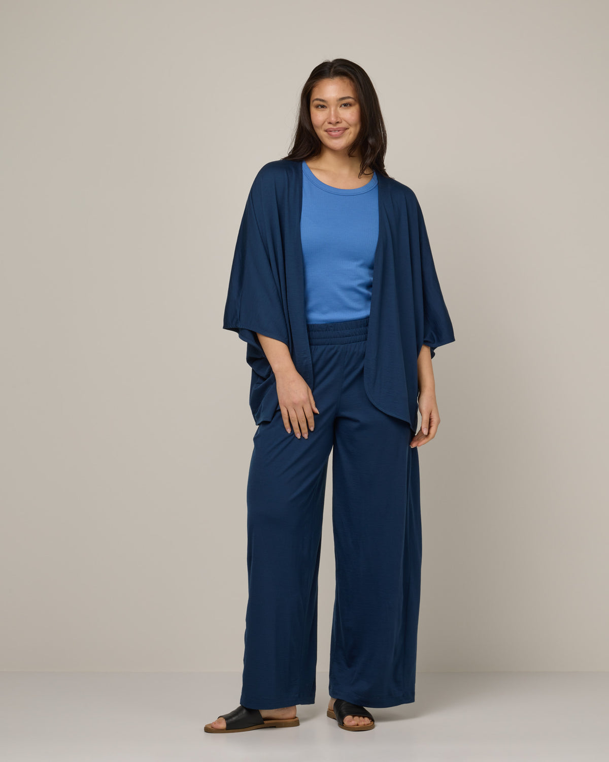Model wearing Lisbon Shawl Cardigan in Marine Blue, a deep royal blue color. Lisbon Shawl Cardigan is a merino wool long sleeve, cardigan available in sizes XS-3X.