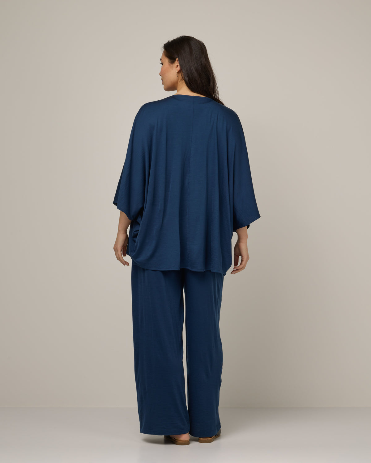 Model wearing Lisbon Shawl Cardigan in Marine Blue, a deep royal blue color. Lisbon Shawl Cardigan is a merino wool long sleeve, cardigan available in sizes XS-3X.