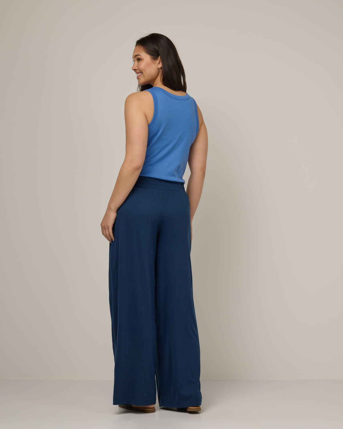 Model wearing Lisbon Palazzo Pant in Marine Blue, a deep royal blue color. Lisbon Palazzo Pant is a merino wool pant available in sizes XS-3X.