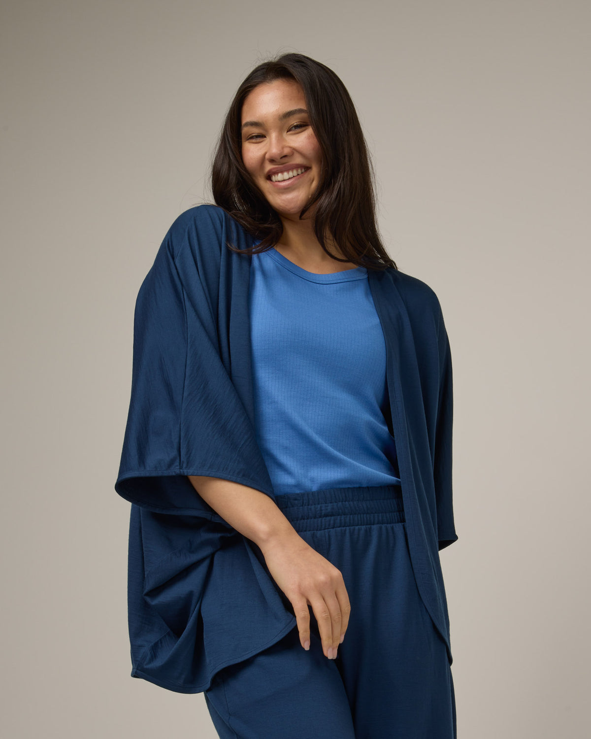 Model wearing Lisbon Shawl Cardigan in Marine Blue, a deep royal blue color. Lisbon Shawl Cardigan is a merino wool long sleeve, cardigan available in sizes XS-3X.