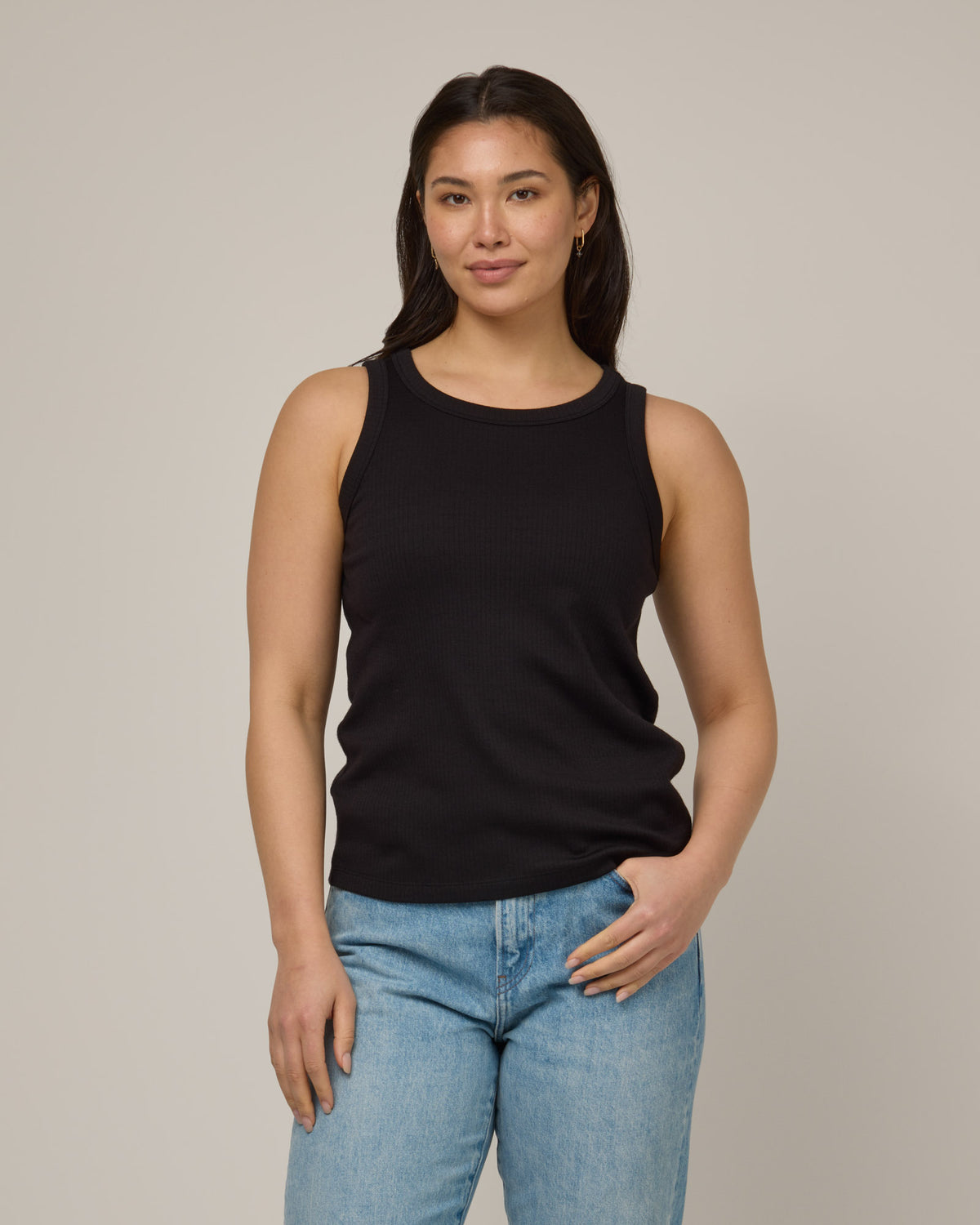 Model wearing Lily Ribbed Tank in Black. Lily Ribbed Tank is a merino wool sleeveless, crew neck, slim fit top available in sizes XS-3X.