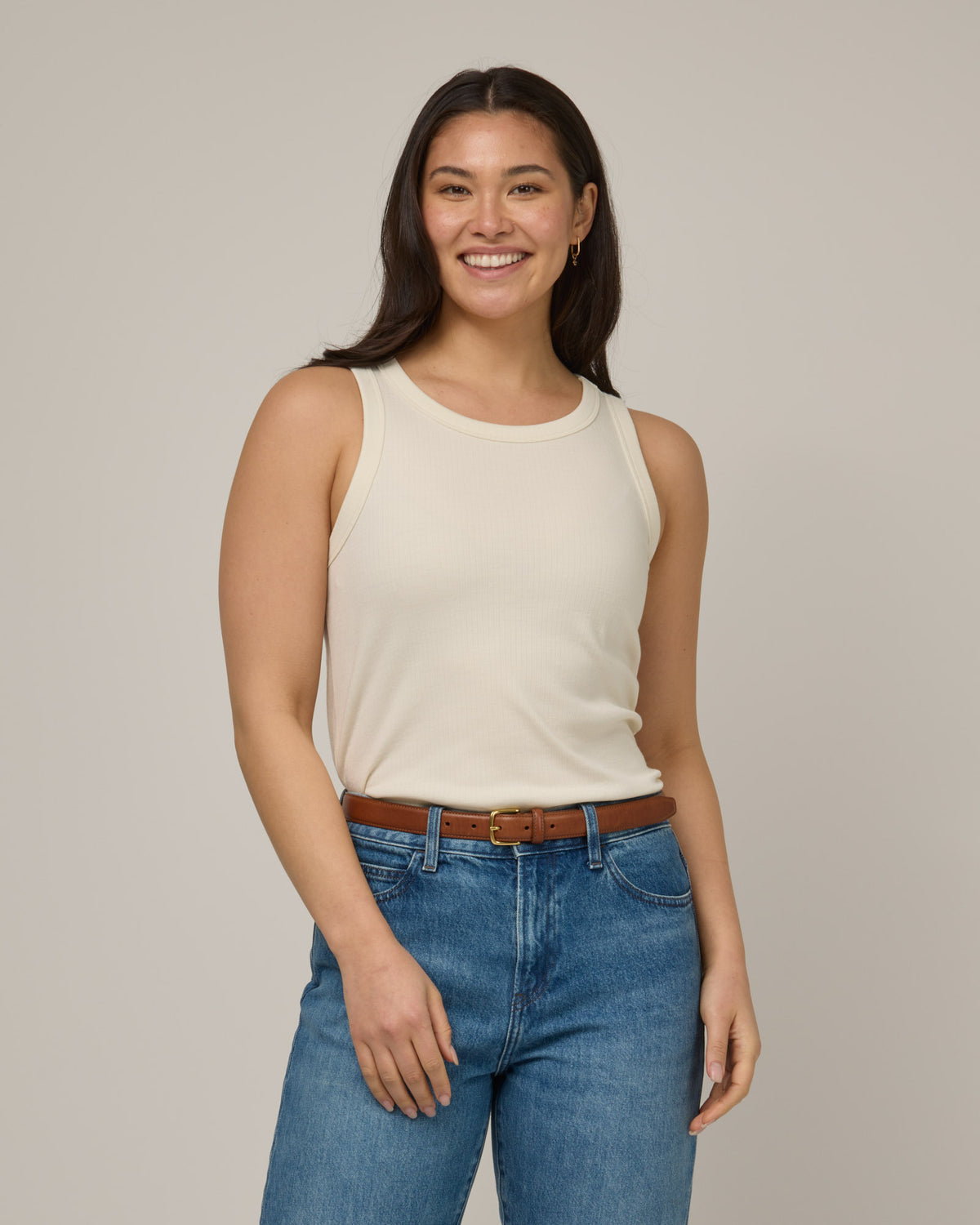 Model wearing Lily Ribbed Tank in Natural White, an off-white cream color. Lily Ribbed Tank is a merino wool sleeveless, crew neck, slim fit top available in sizes XS-3X.