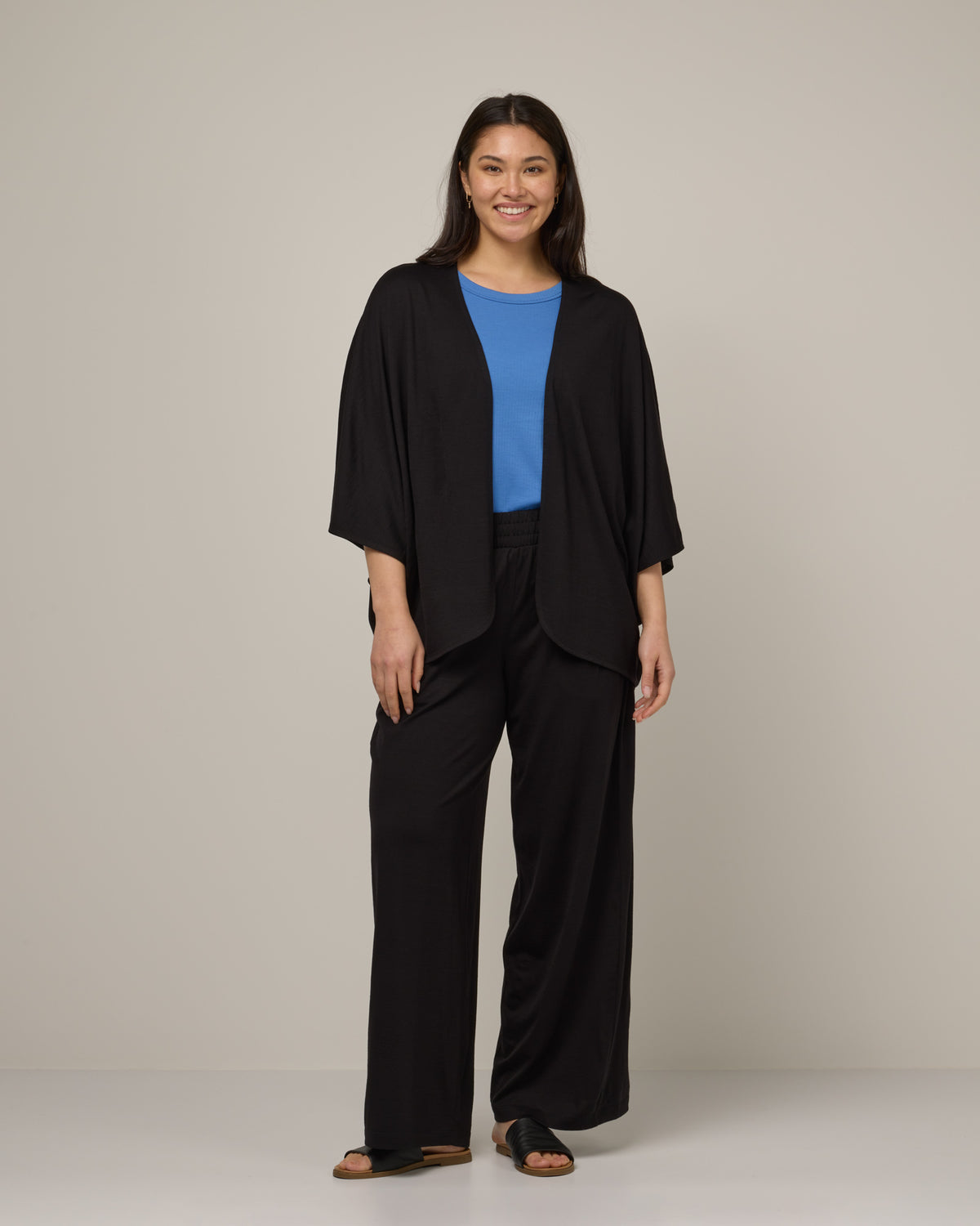 Model wearing Lisbon Shawl Cardigan in Black. Lisbon Shawl Cardigan is a merino wool long sleeve, cardigan available in sizes XS-3X.