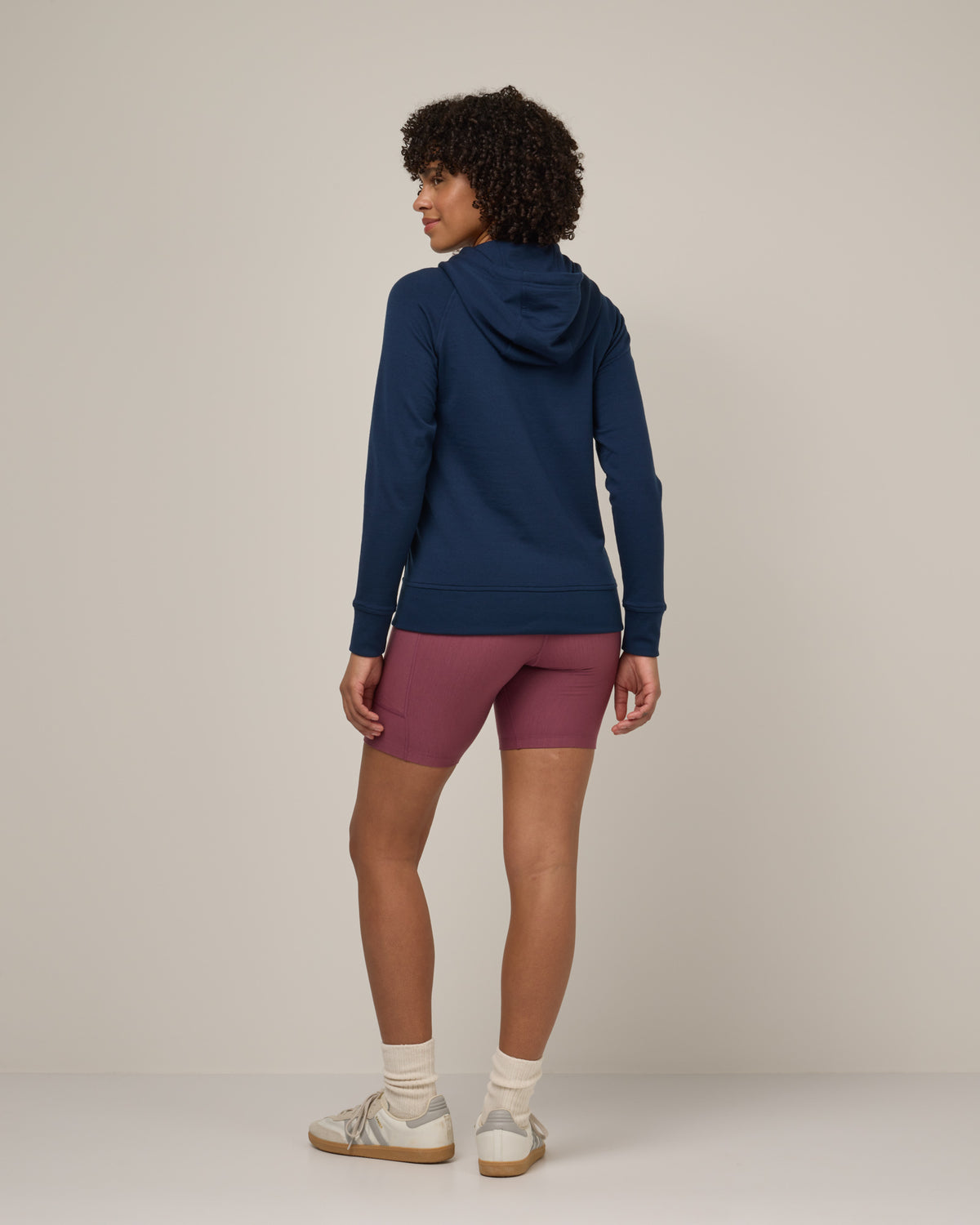 Model wearing Aspen Full-Zip Hoodie in Marine Blue, a deep royal blue color. Aspen Full-Zip Hoodie is a merino wool long sleevezip hoodie with pockets available in sizes XS-3X.