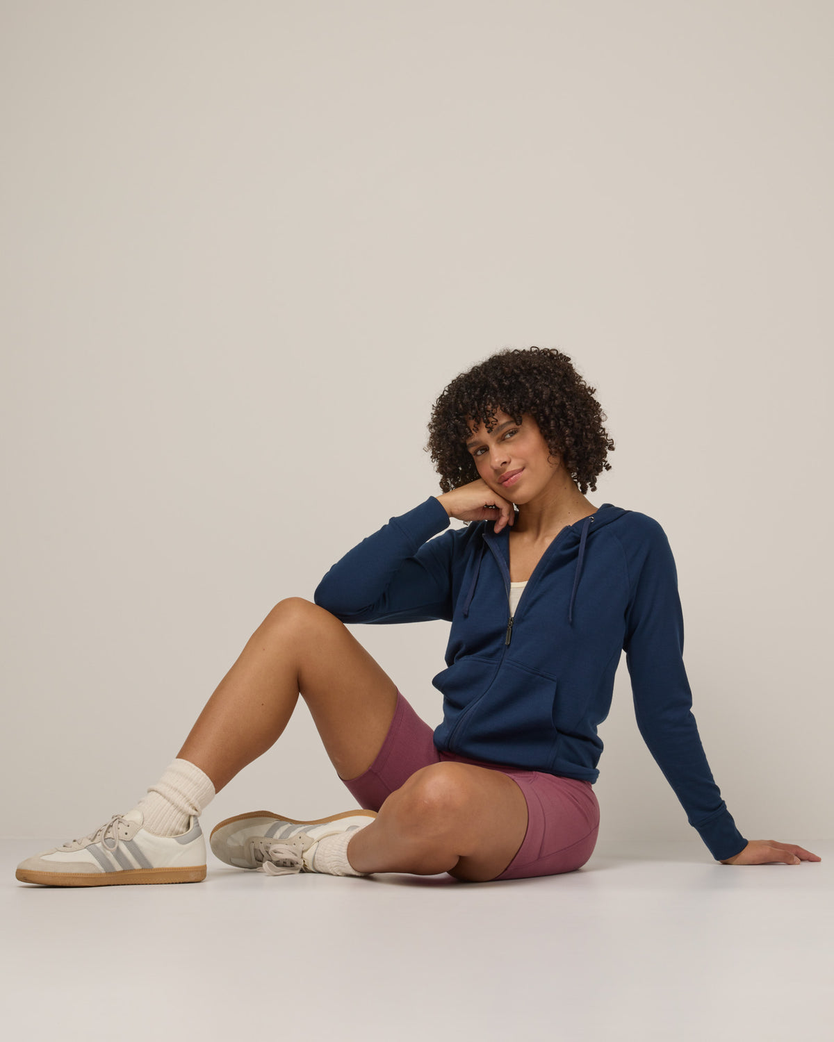 Model wearing Aspen Full-Zip Hoodie in Marine Blue, a deep royal blue color. Aspen Full-Zip Hoodie is a merino wool long sleevezip hoodie with pockets available in sizes XS-3X.