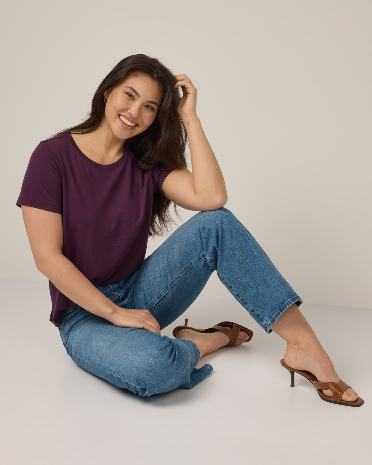 Model wearing Zoe Easy Crew Neck Tee in Marionberry, a dark berry purple color. Zoe Easy Crew Neck Tee is a merino wool short sleeve, crew neck, regular fit tee available in sizes XS-3X.