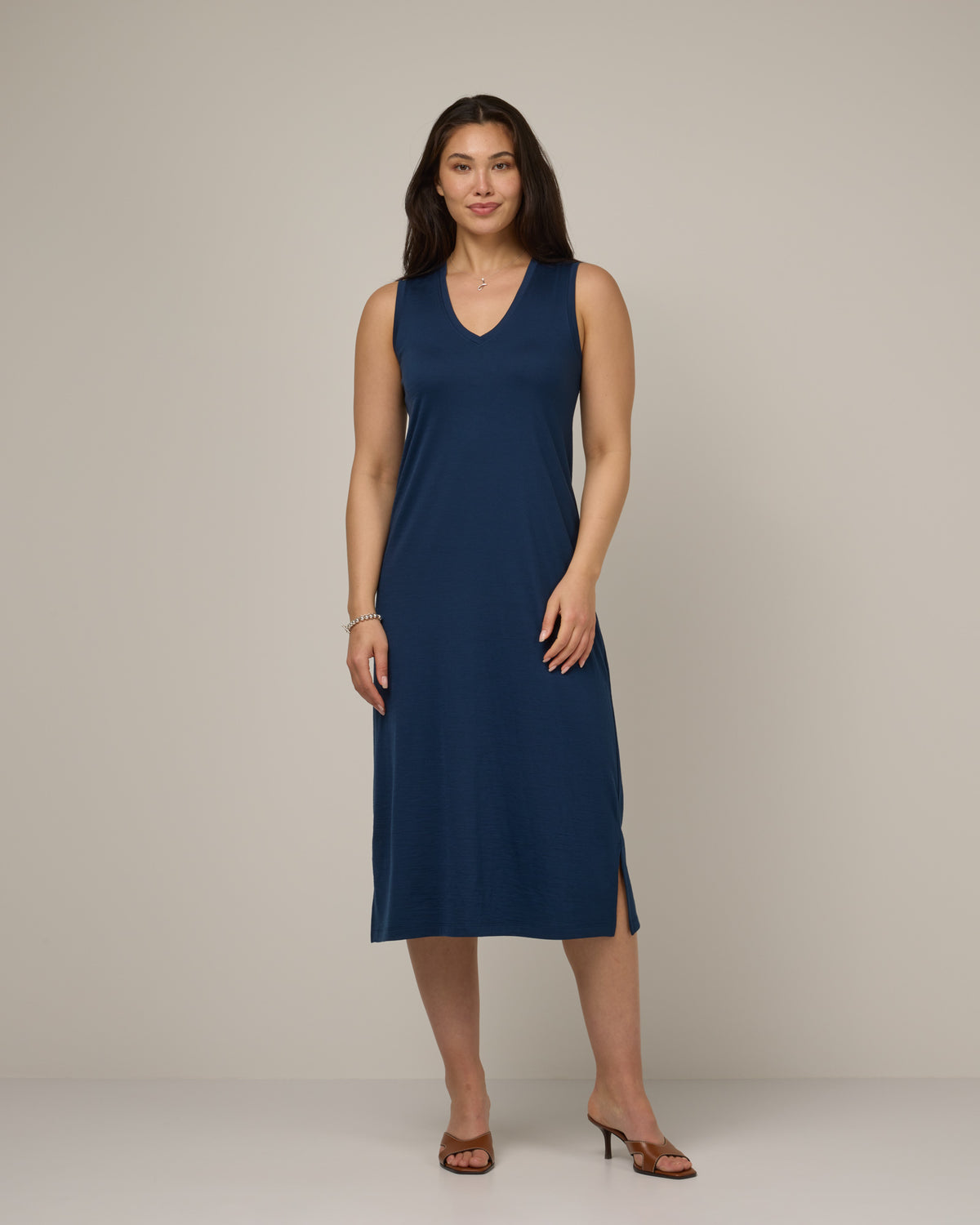 Model wearing Milena Shift Dress in Marine Blue, a deep royal blue color. Milena Shift Dress is a merino wool sleeveless, v-neck, midi shift dress available in sizes XS-3X regular, XS-XL petite.