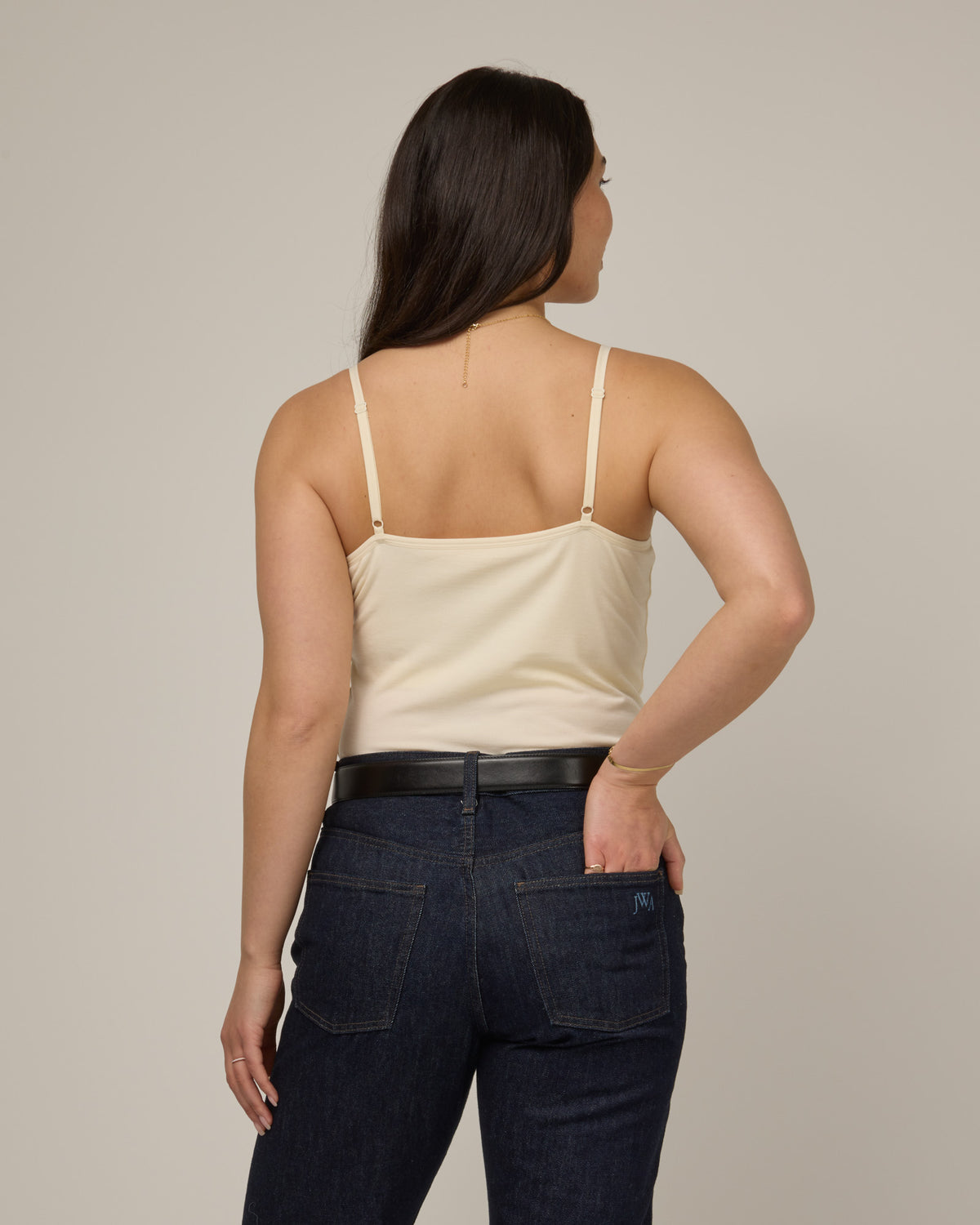 Model wearing Roam Shelf Bra Cami in Natural White, an off-white cream color. Roam Shelf Bra Cami is a merino wool sleeveless, scoop neck, slim fit top available in sizes XS-XXL.