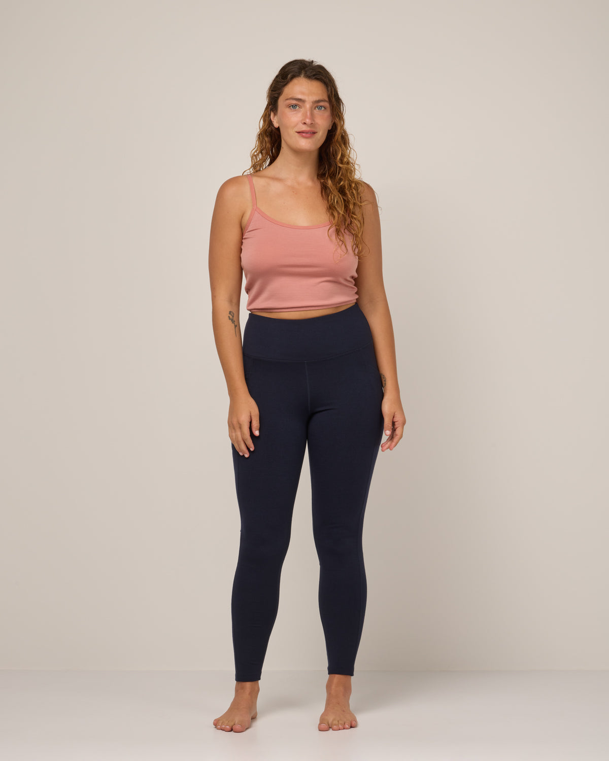 Model wearing Summit Pocket Legging in Navy. Summit Pocket Legging is a merino wool legging with pockets available in sizes XS-3X Regular, S-XXL Long.