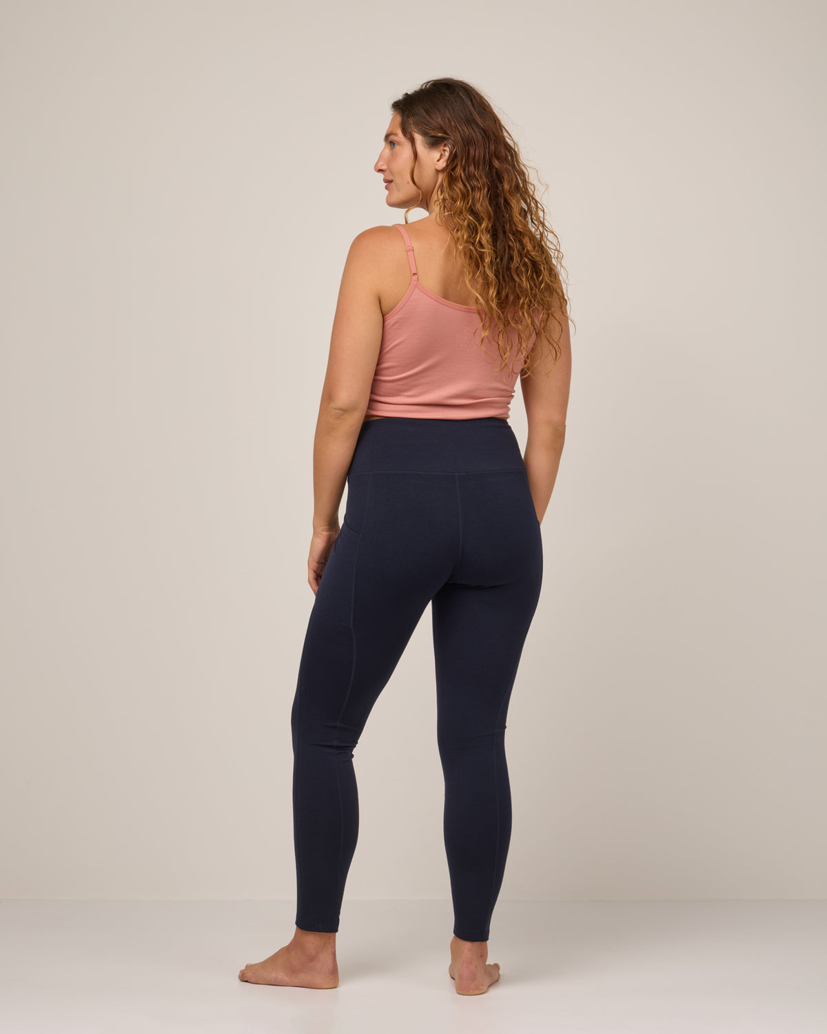 Model wearing Summit Pocket Legging in Navy. Summit Pocket Legging is a merino wool legging with pockets available in sizes XS-3X Regular, S-XXL Long.