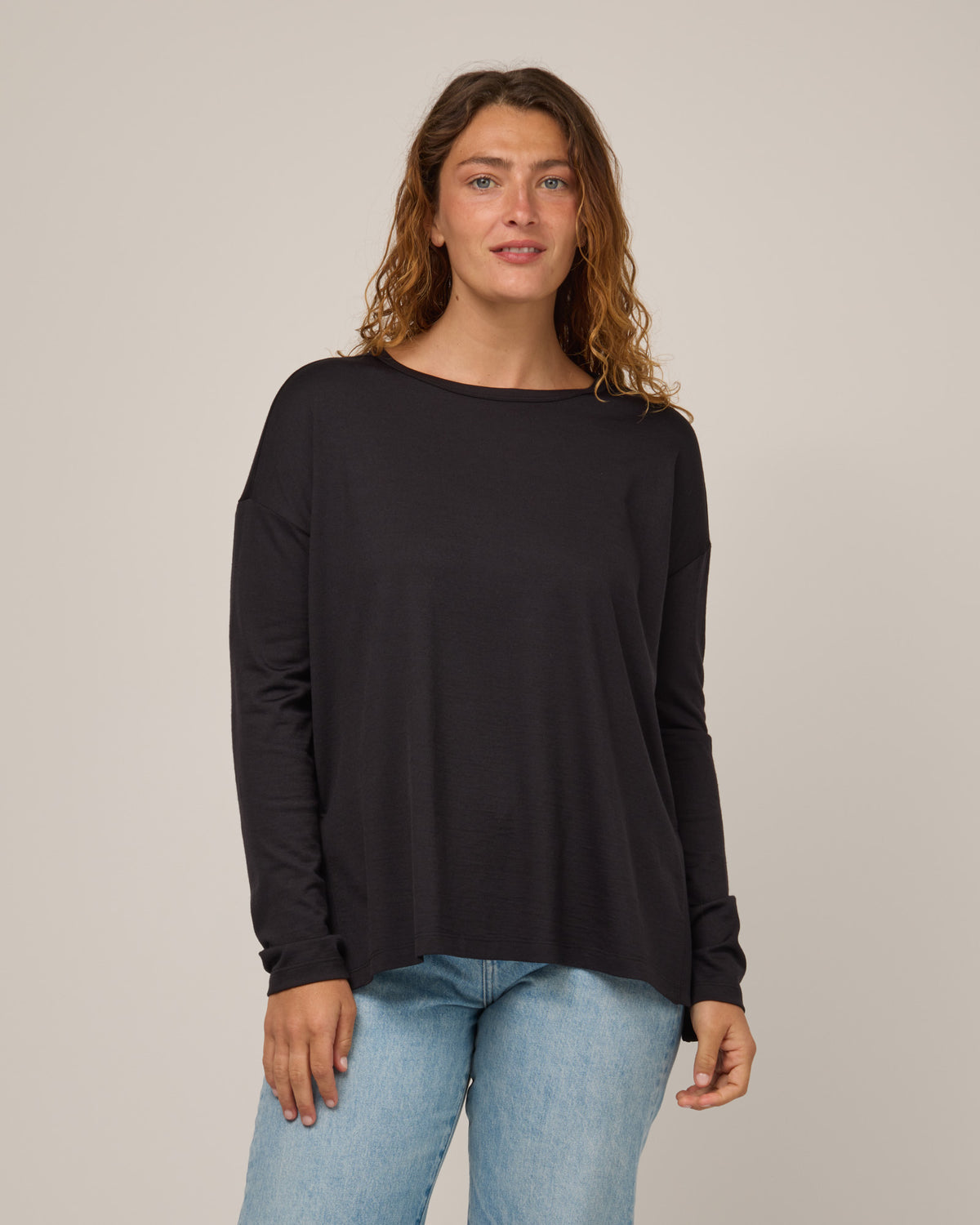 Model wearing Abby Boatneck Top in Black. Abby Boatneck Top is a merino wool long sleeve, boatneck, relaxed fit top available in sizes XS-3X.
